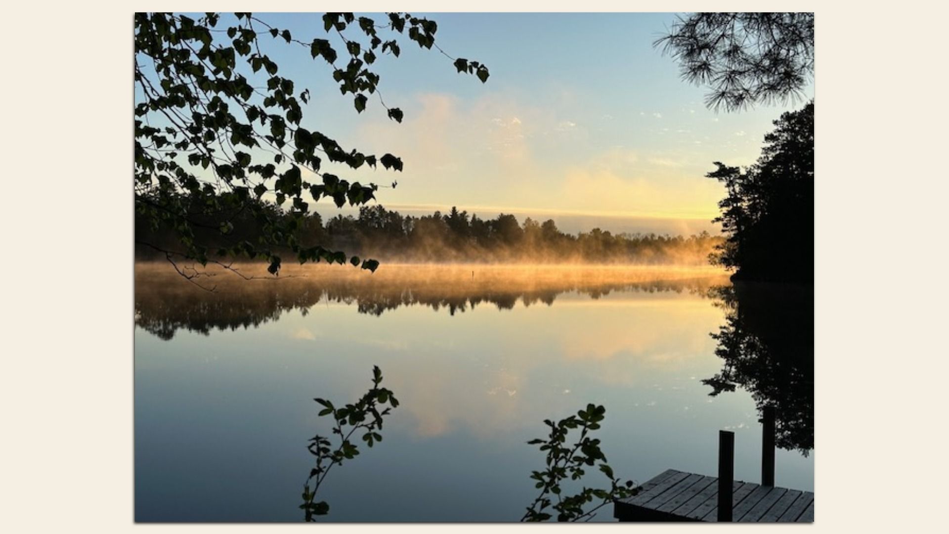 A view of sunrise and mist over a lake