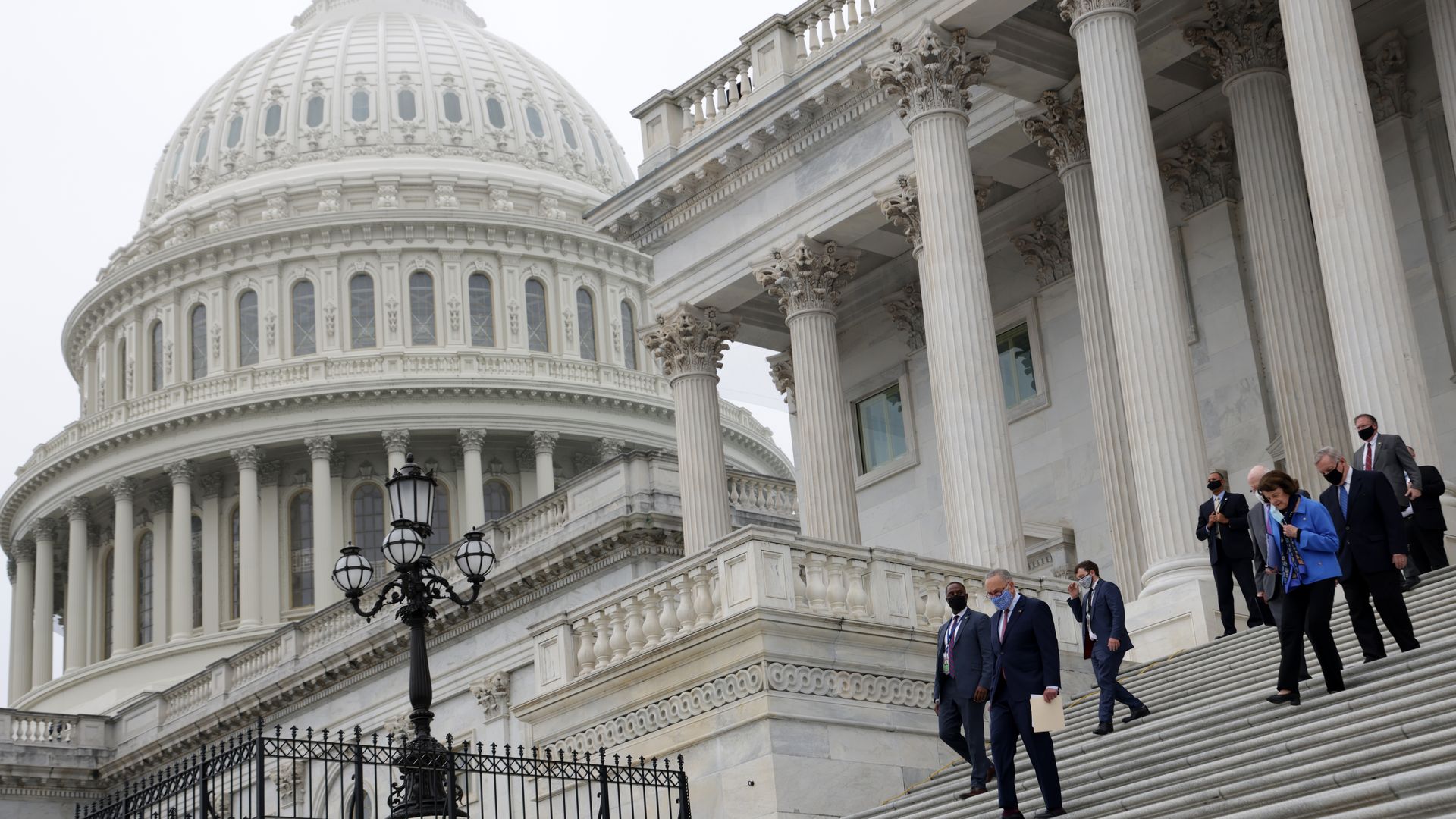 Senators walking down the steps outside the Capitol building.