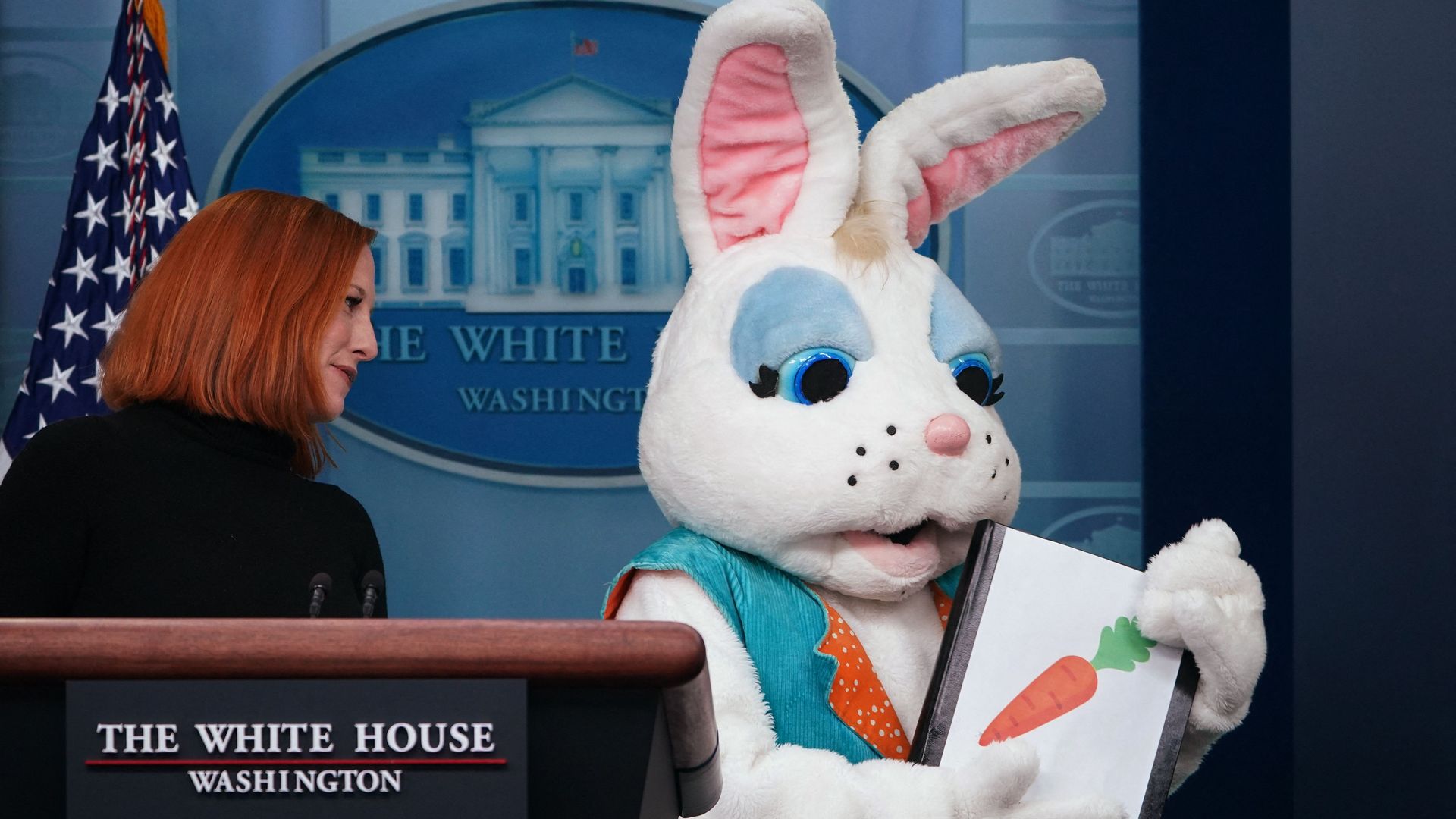 White House press secretary and a costumed Easter Bunny share the podium in the White House briefing room