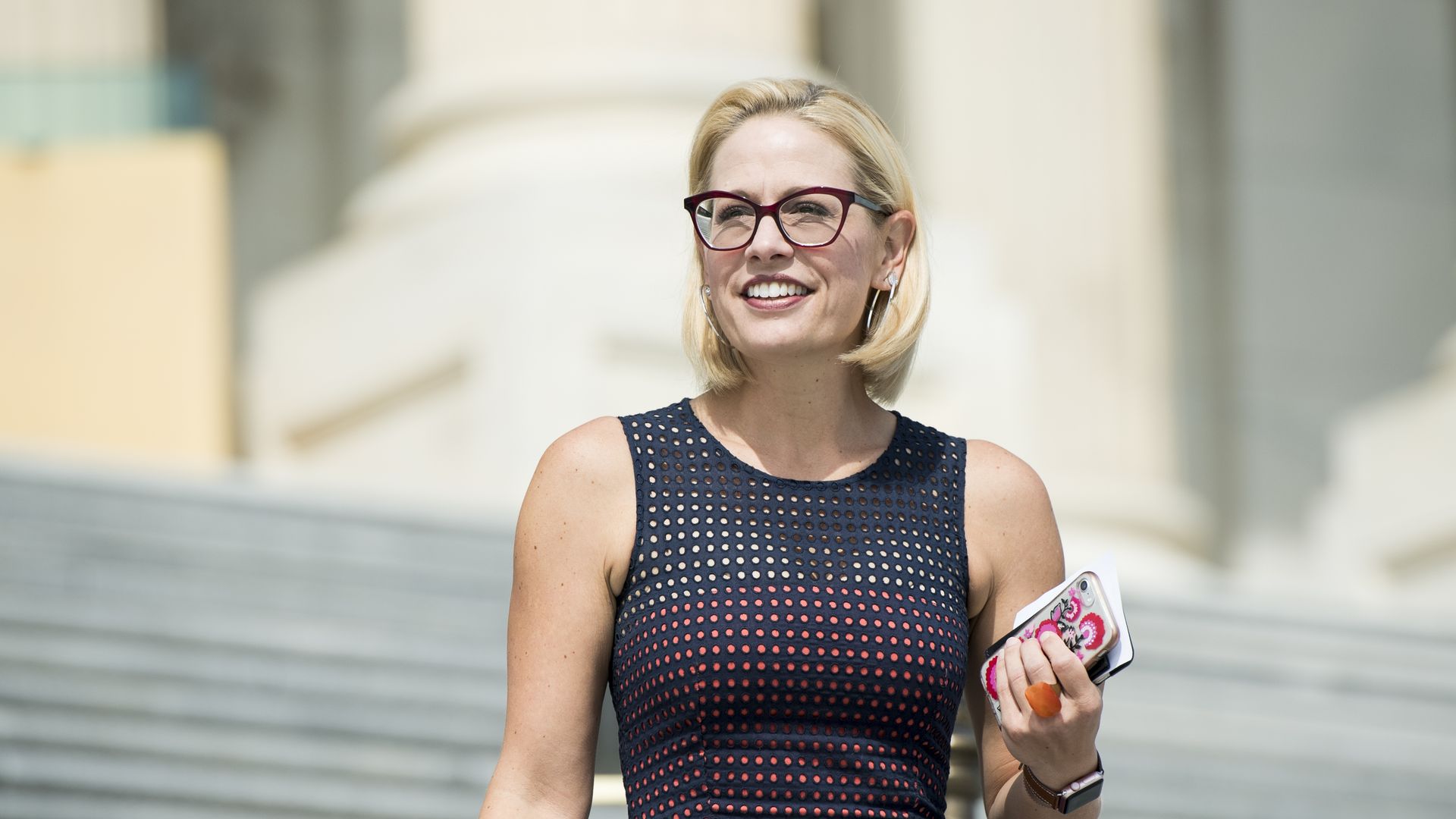 Sen. Krysten Sinema is seen on the Capitol steps.