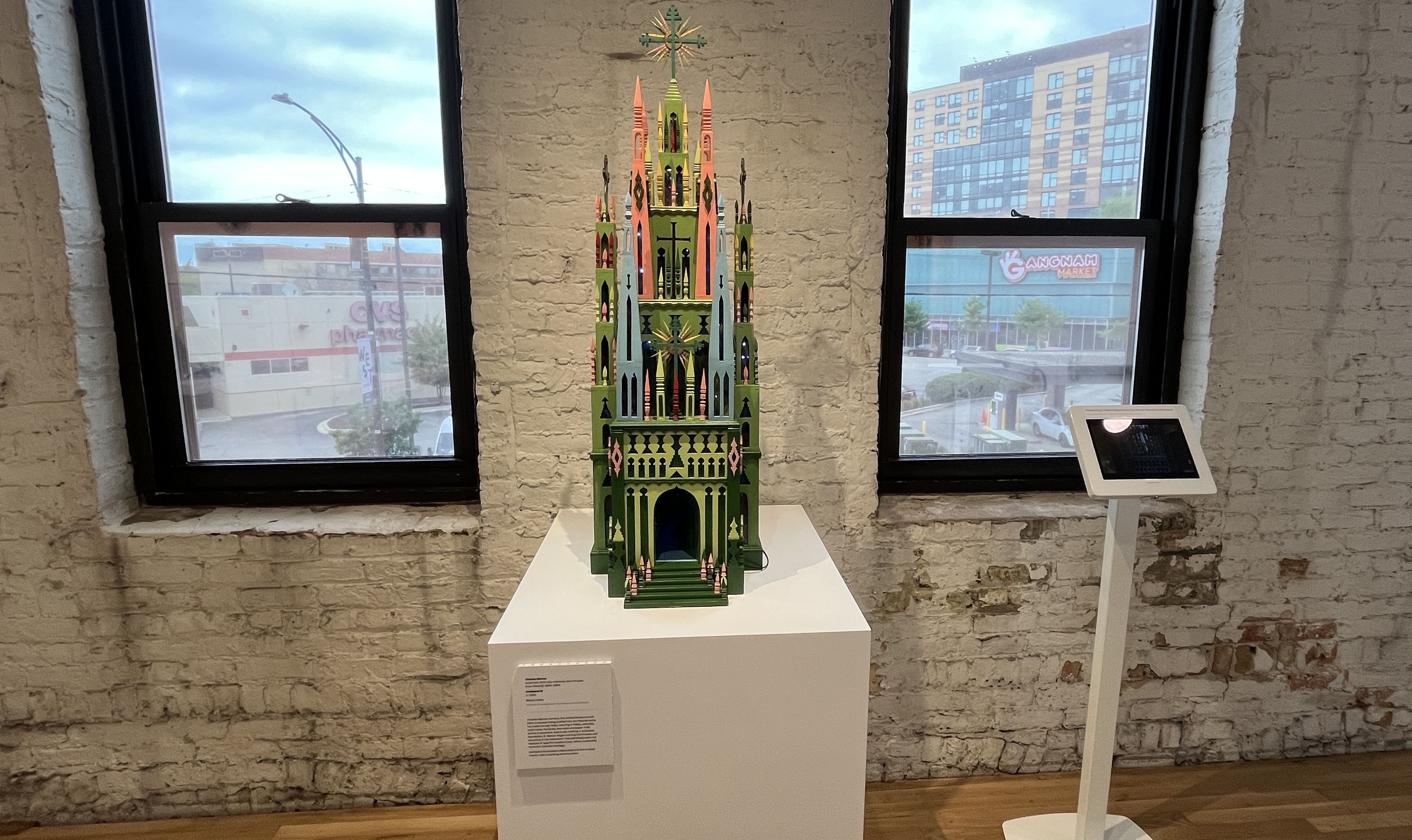 sculpture of a multi-colored castle on a white podium.