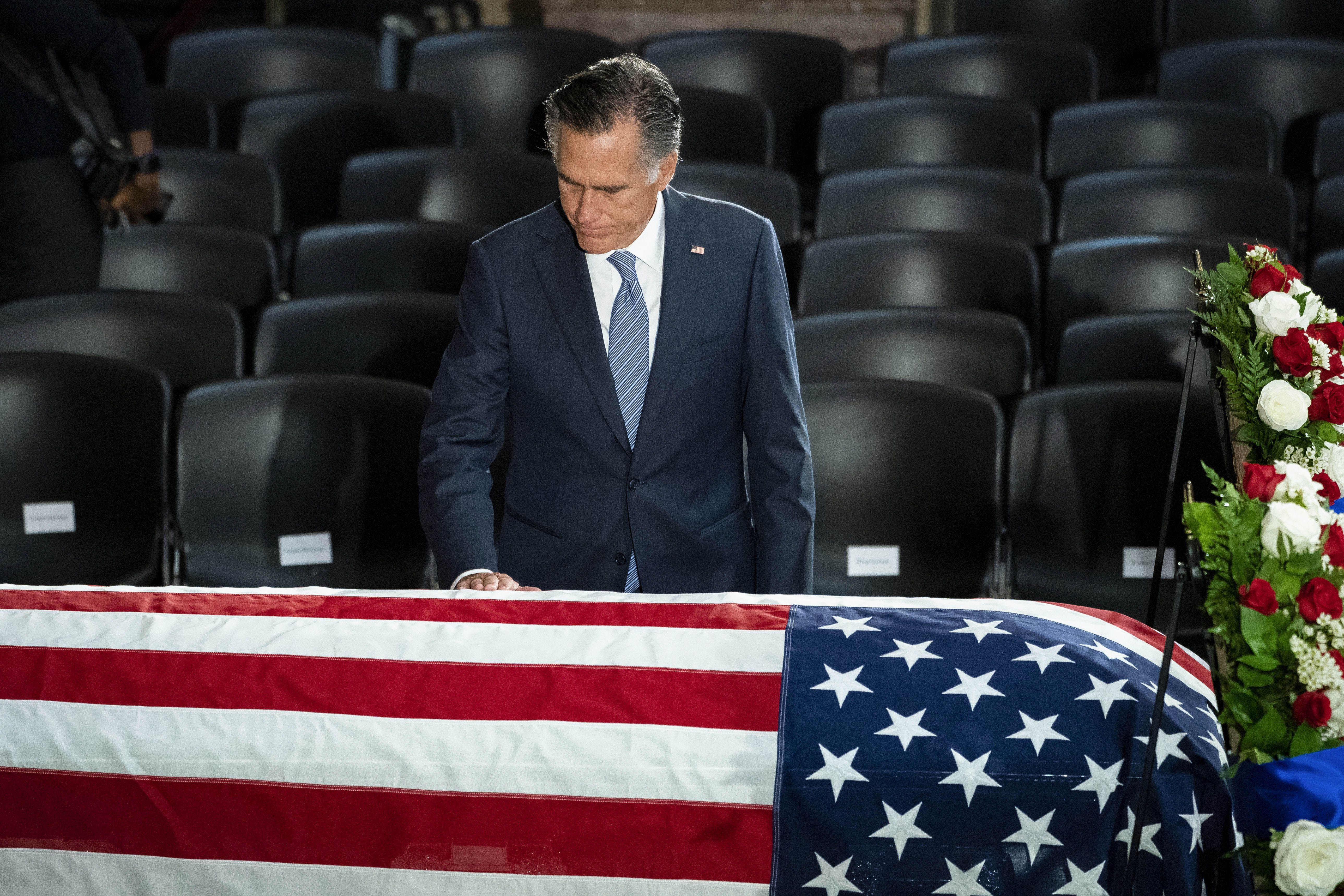 Senator Mitt Romney touches Elijah Cummings' casket.