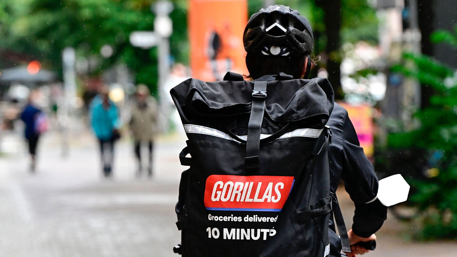 A bicycle courier of grocery delivery company Gorillas wears a backpack with the logo of the startup on his way to deliver purchases in Berlin.