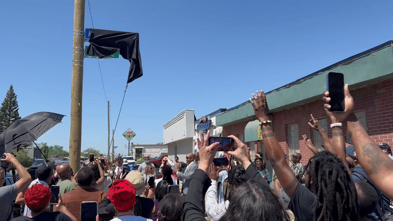 The sign gets unveiled to applause and excited onlookers