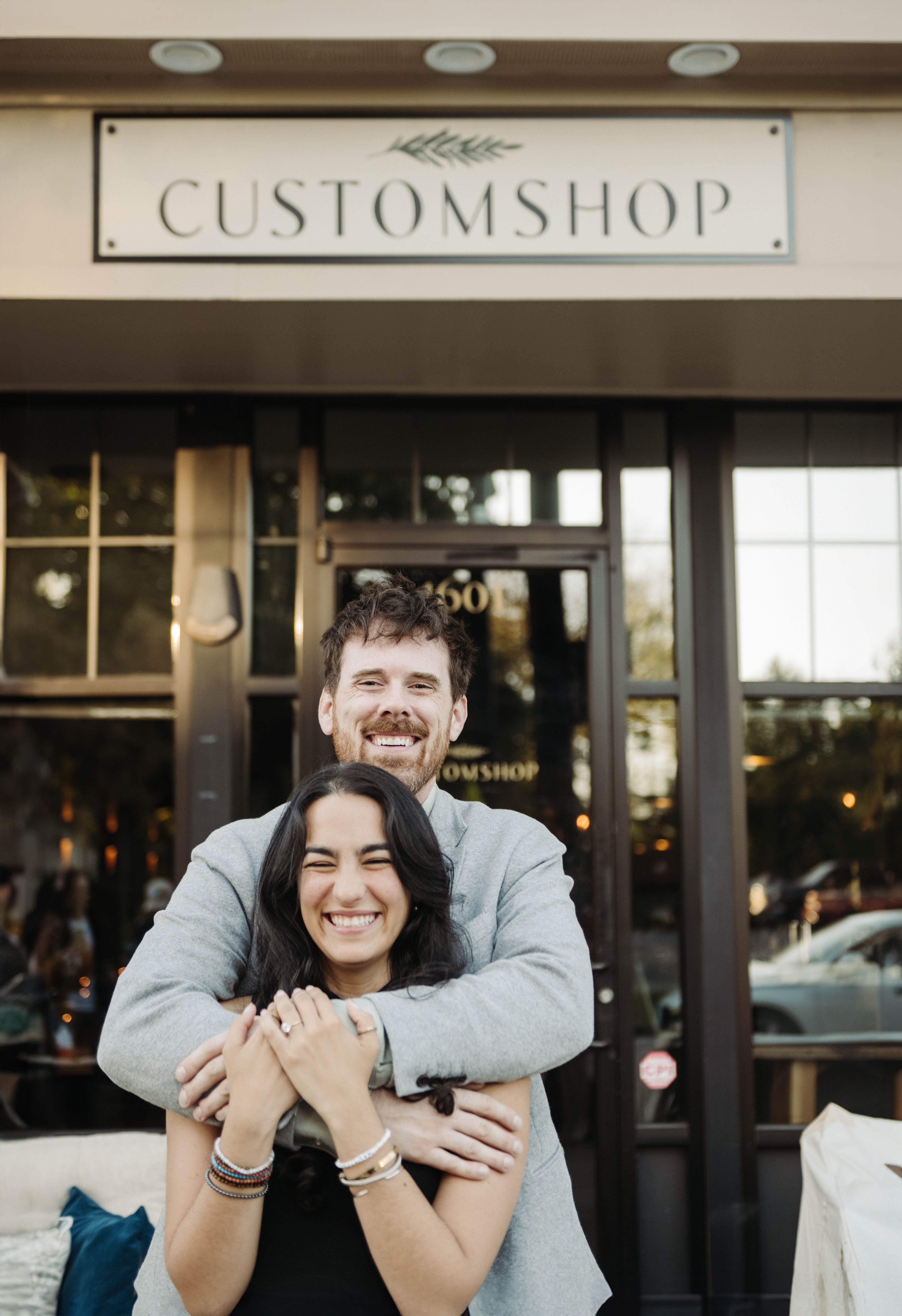 two people hugging outside of Customshop restaurant