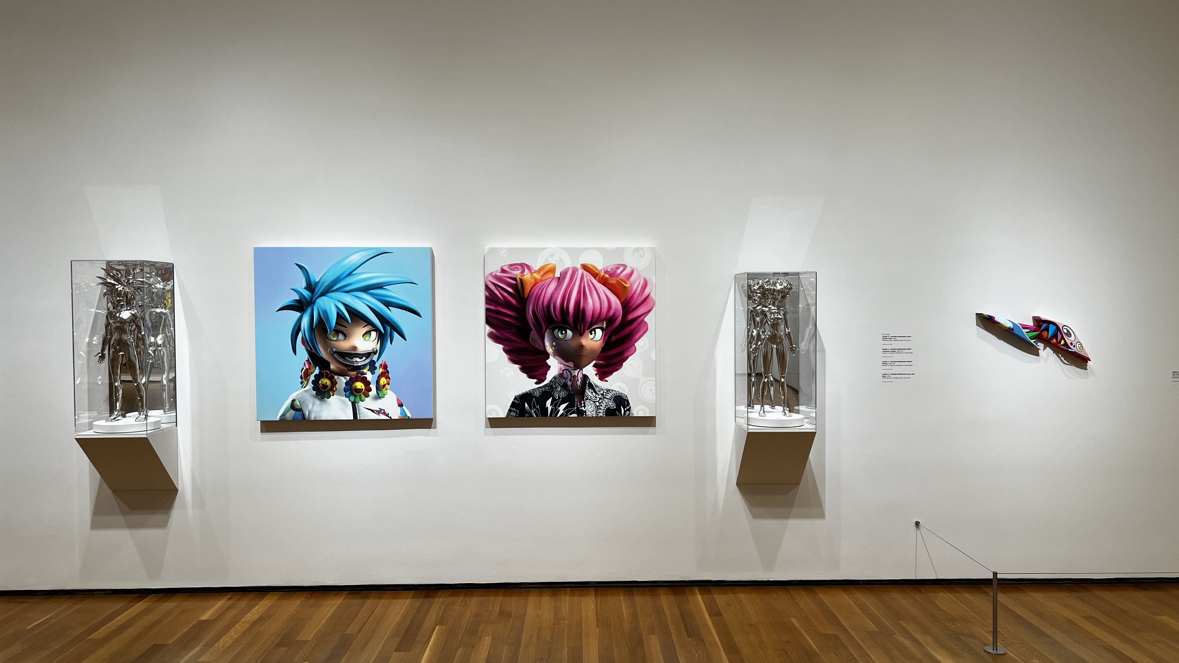 Japanese sculptures and art on a wall in a gallery. 