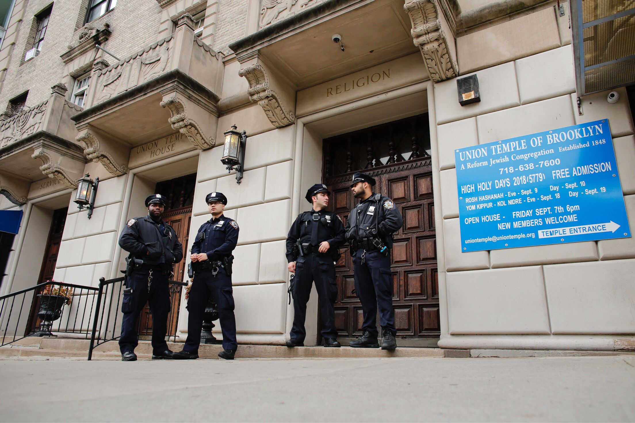 NYPD officers guard a Brooklyn temple in 2018 after antisemitic graffiti was found.