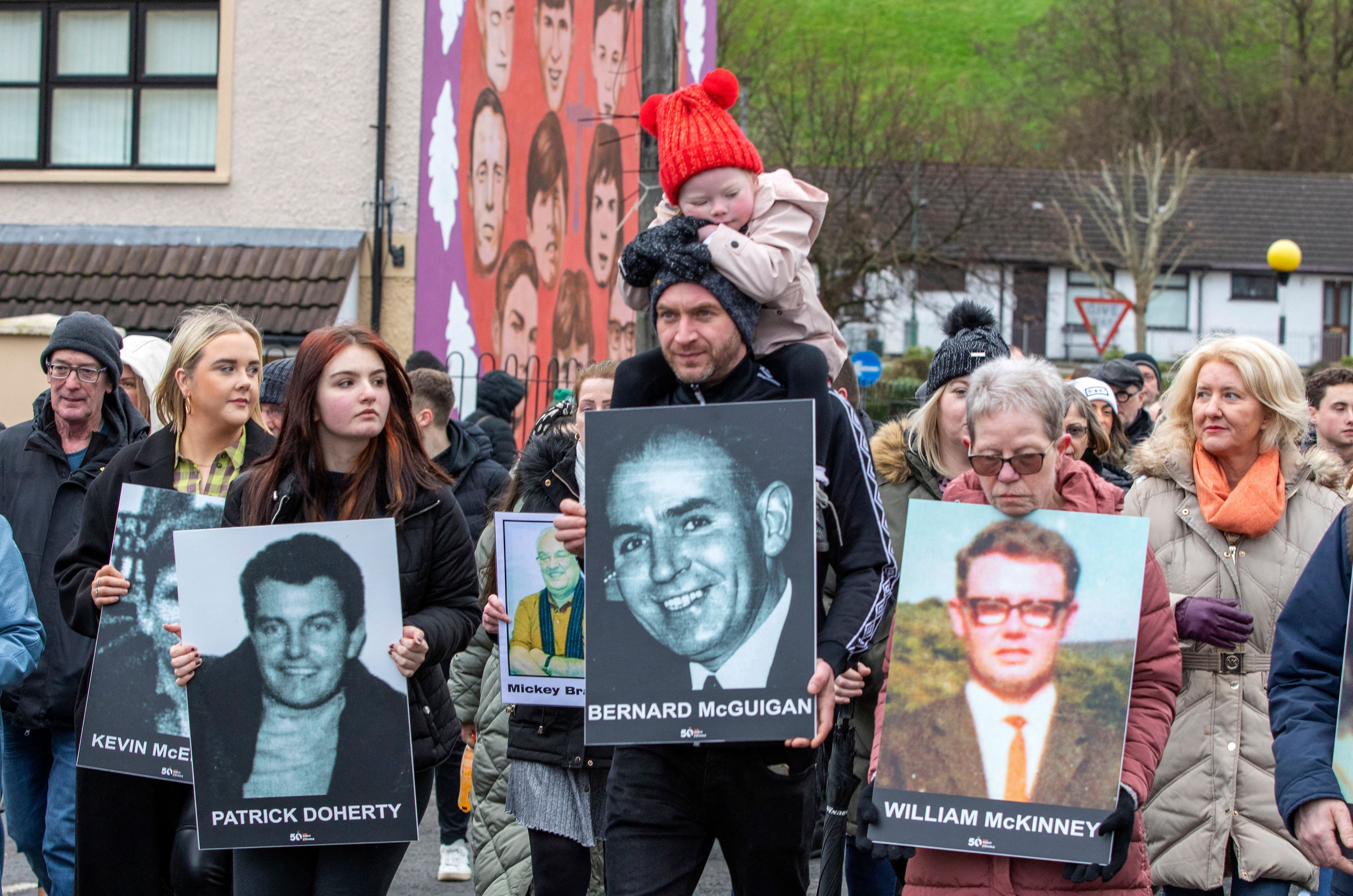 Family members carry photographs of those killed on Bloody Sunday at a memorial march to the Bogside for a wreath laying ceremony at a monument to those killed on the day,