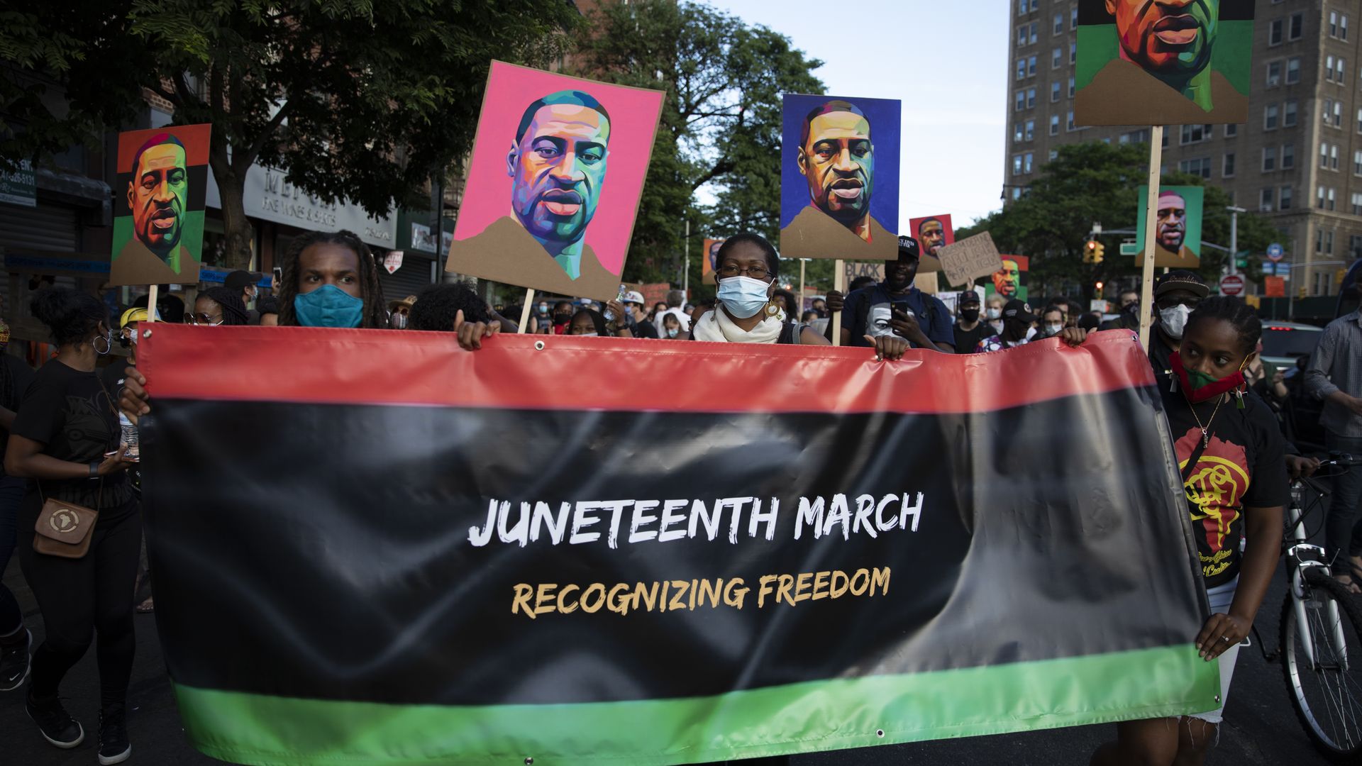 Protesters carry banners and posters of George Floyd during the Juneteenth march on June 19, 2020 in the Brooklyn.
