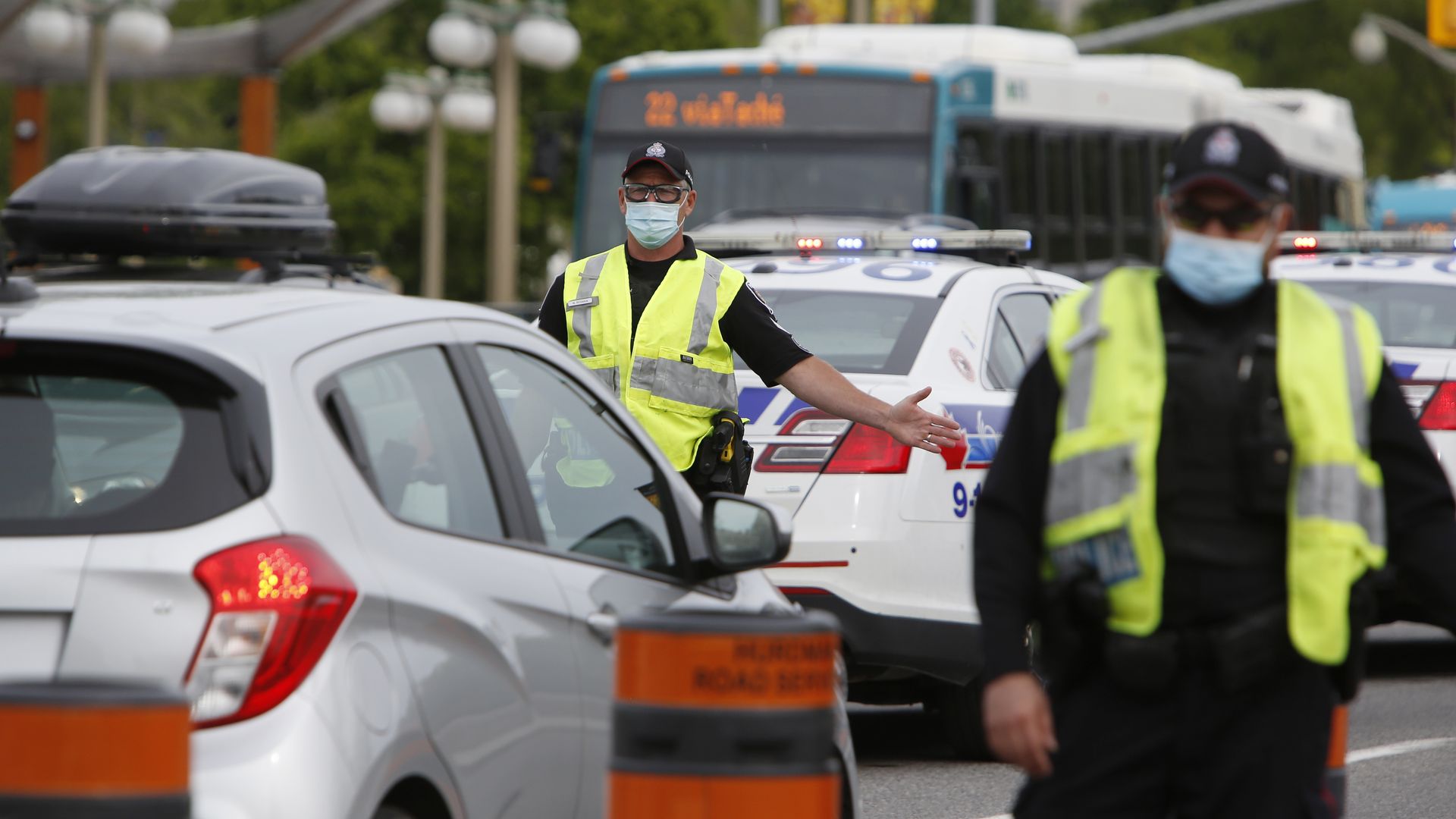 Police officers screen travelers before entering the border. 