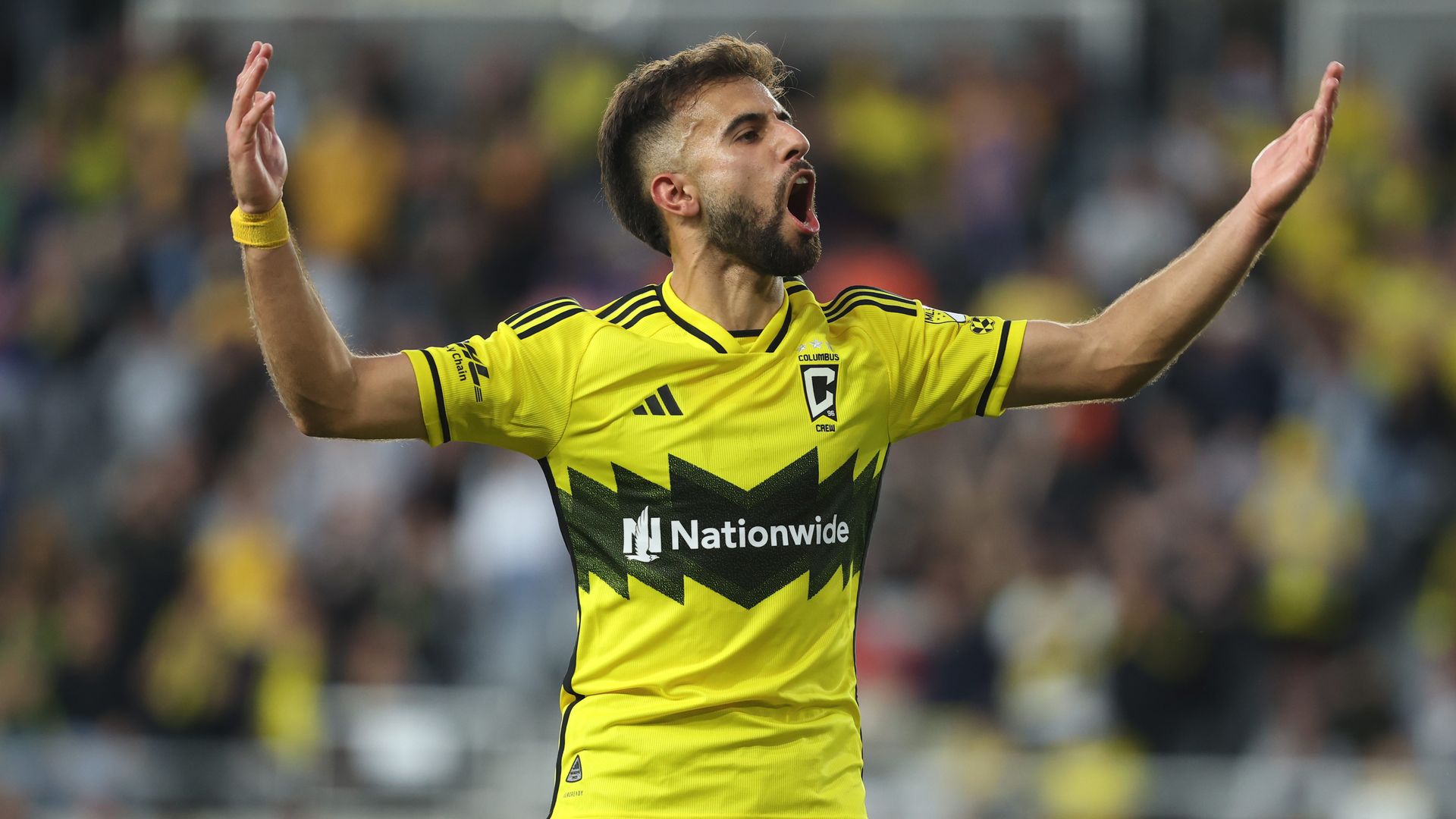 Crew forward Diego Rossi throws his hands in the air to celebrate his goal against FC Cincinnati