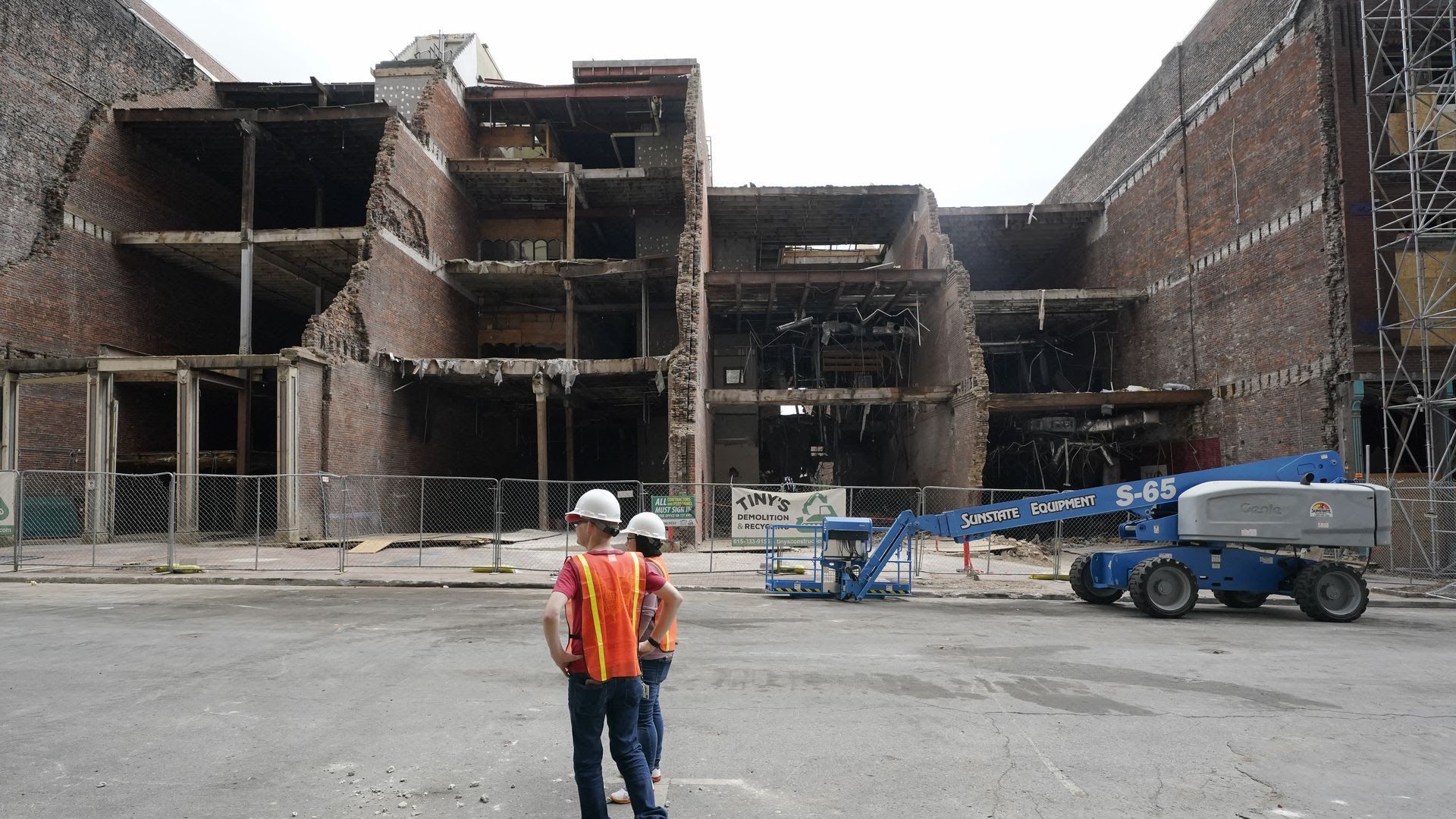 Workers survey the bombing recovery of Nashville's second avenue in June 2021.