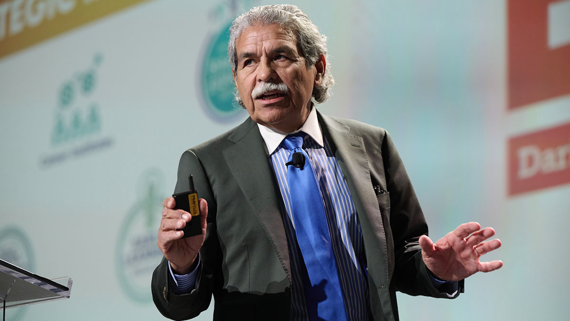 A man in a suit talks on stage