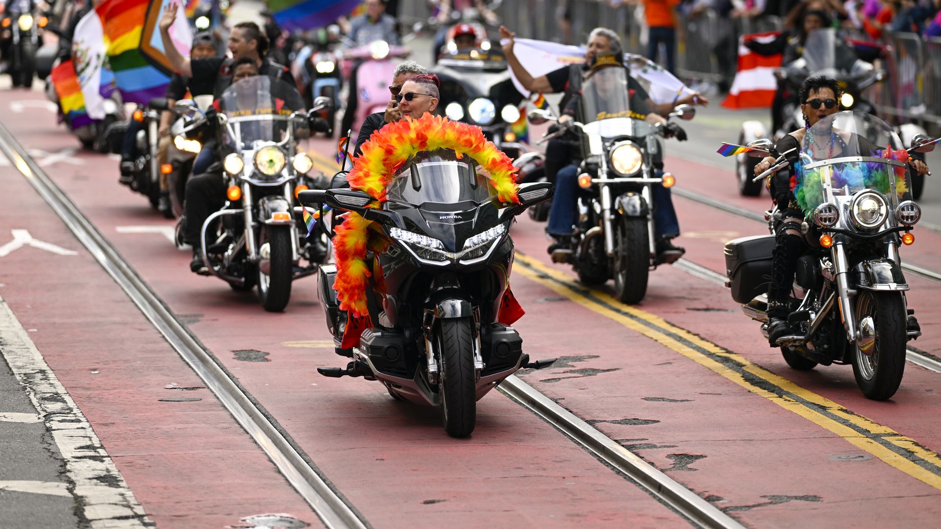 A woman on a motorcycle during a Pride parade