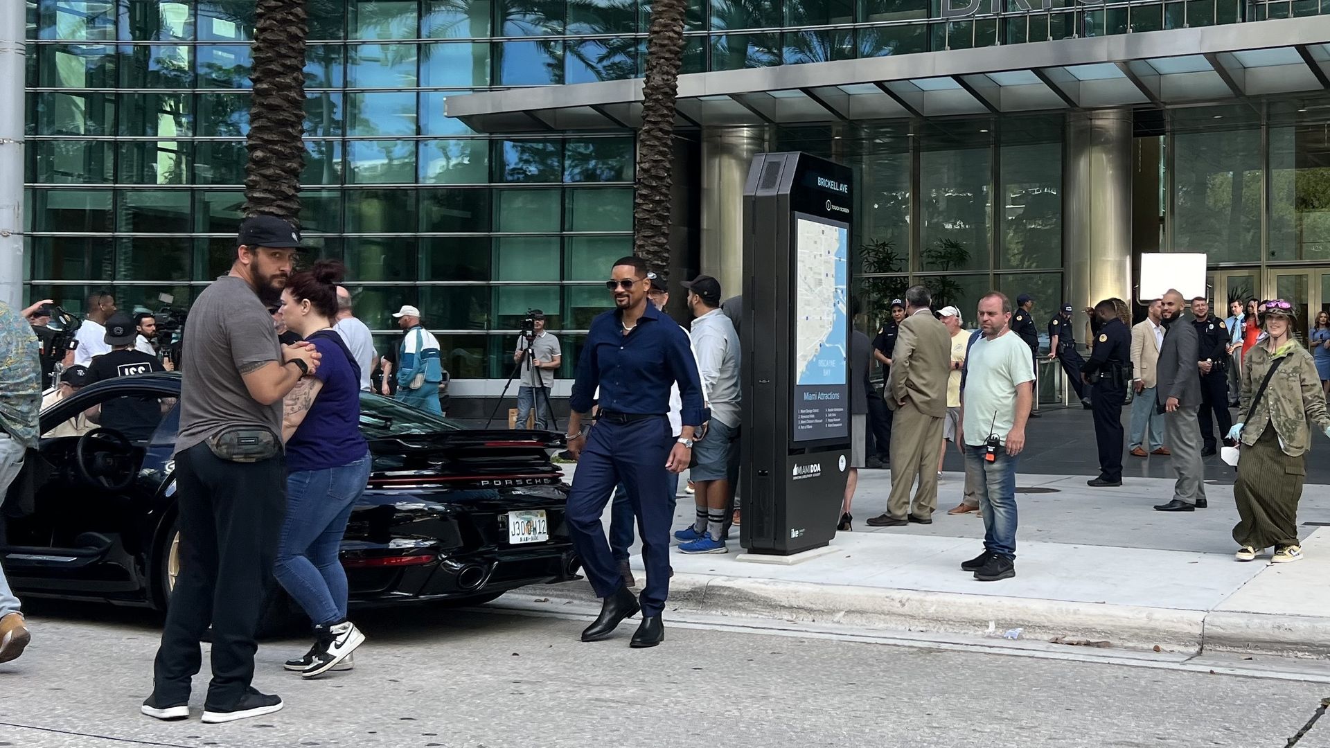 Actor Will Smith walks into the street to get inside a black Porche coupe. 
