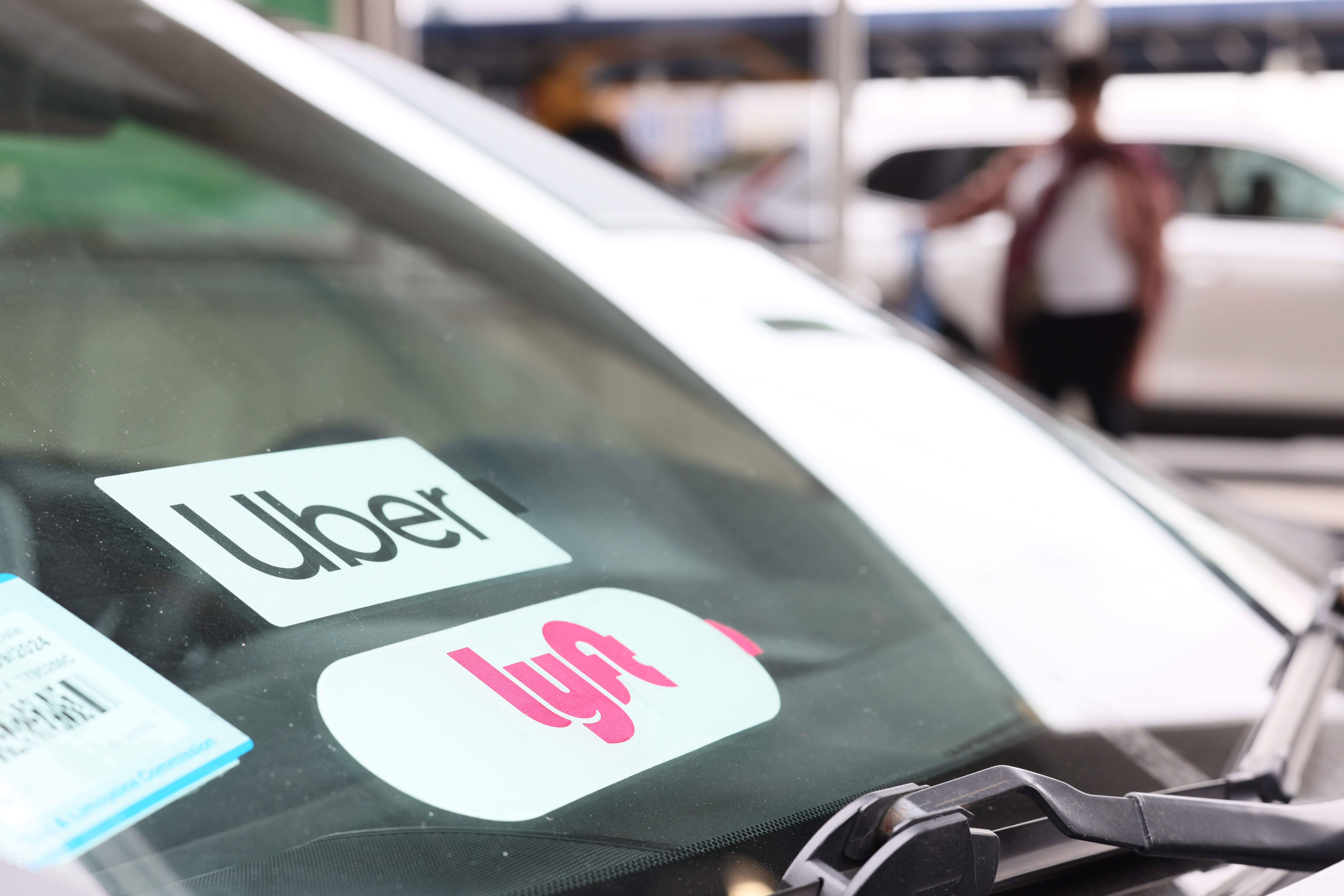 Car windshield with Uber and Lyft stickers