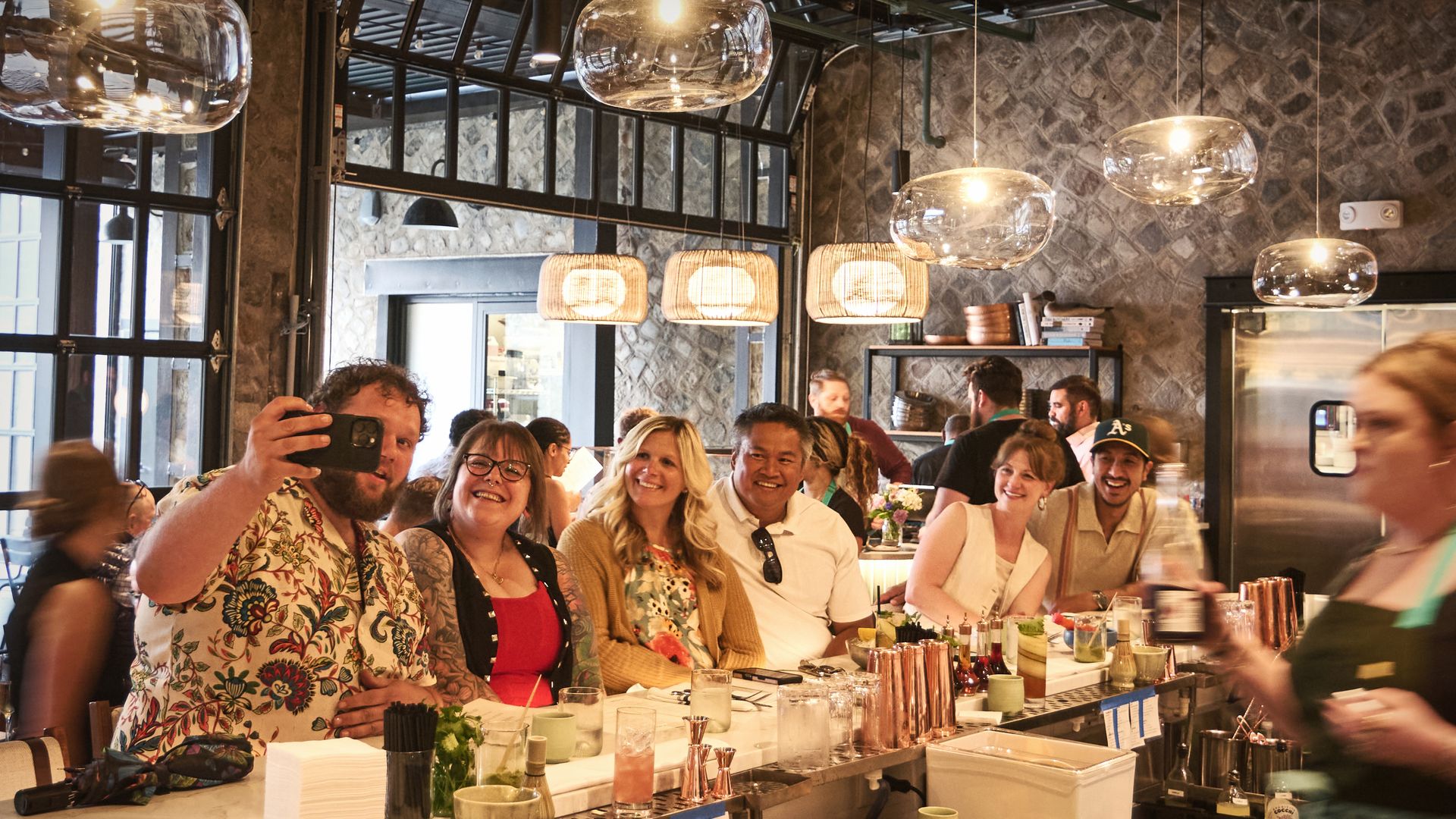 A crowd of people take a selfie at a bar 