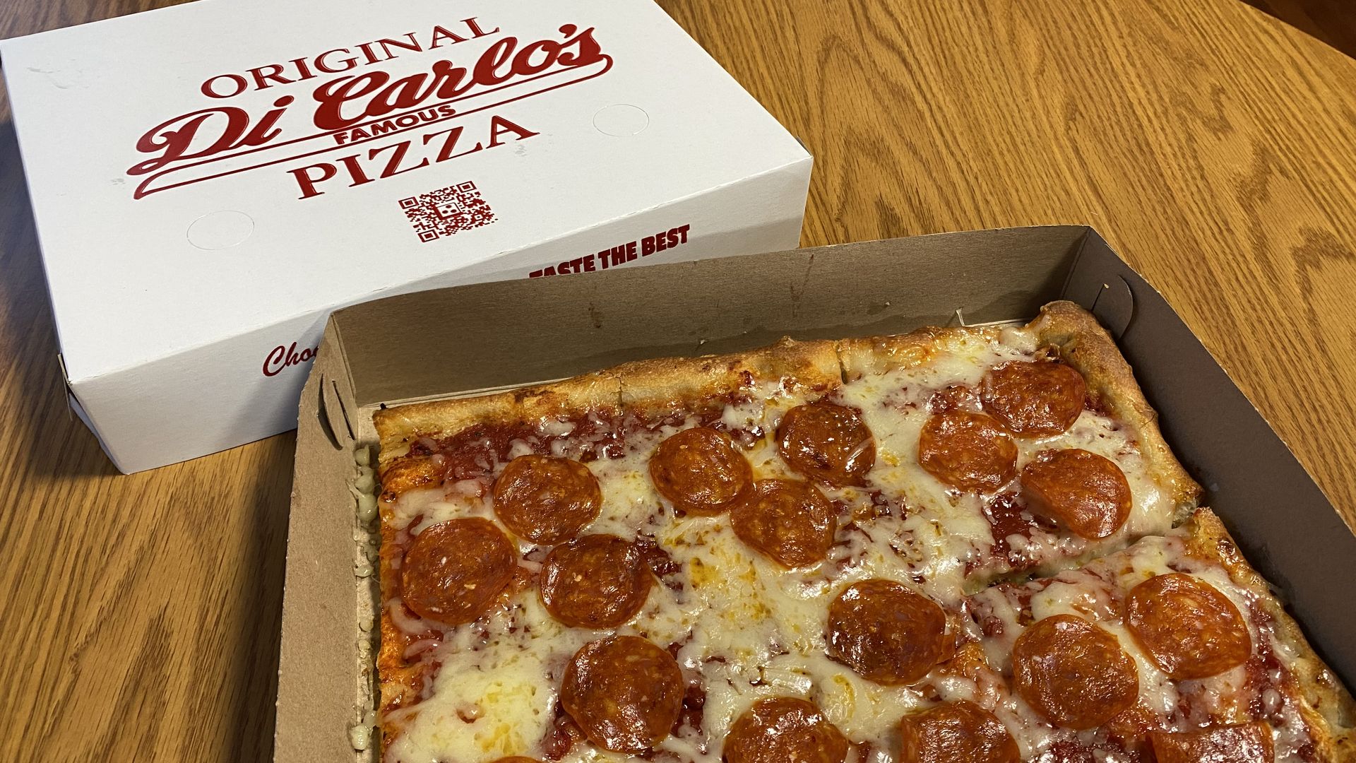 A DiCarlo's Pizza box and a square pizza