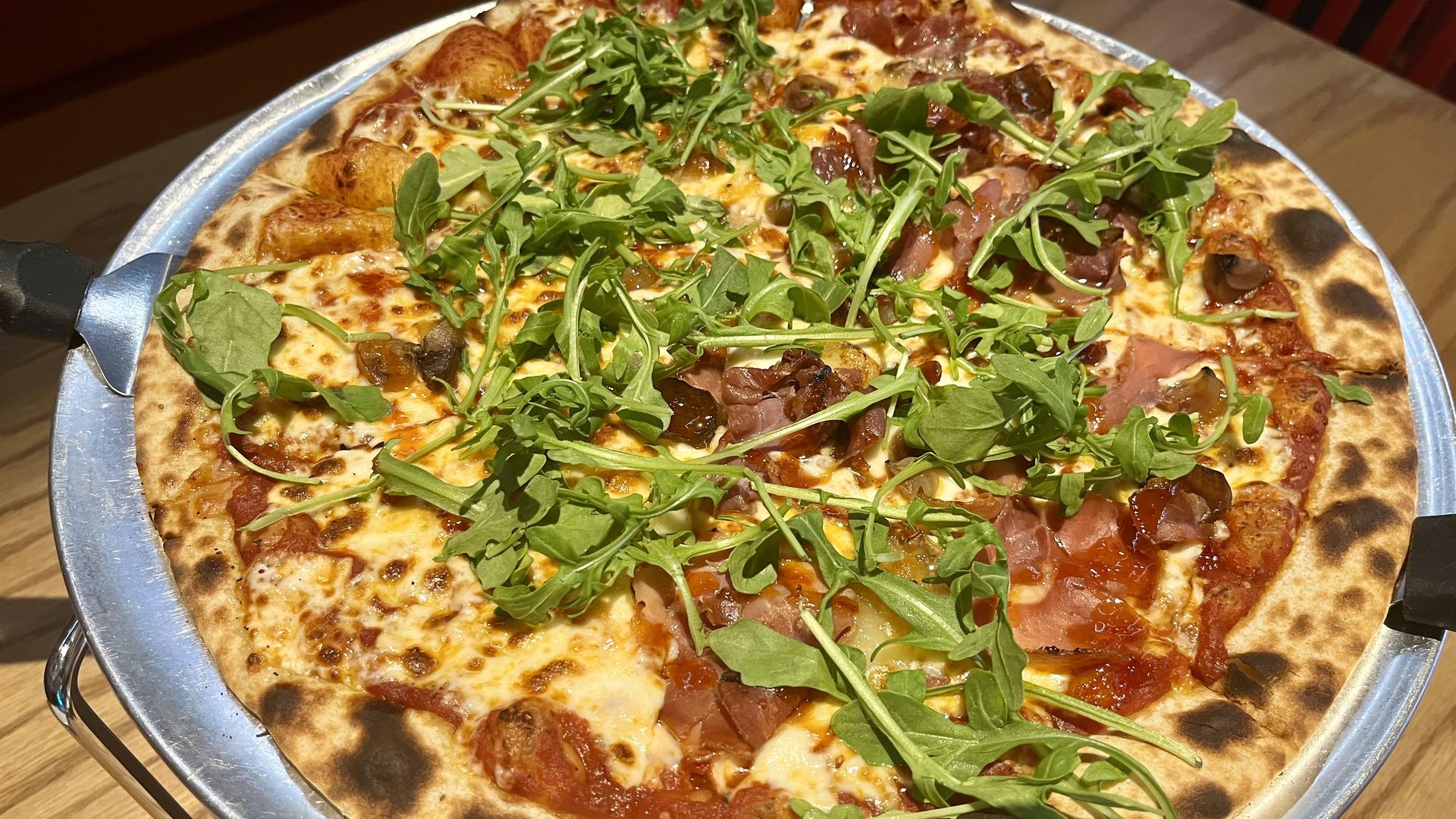A round pizza topped with arugula.