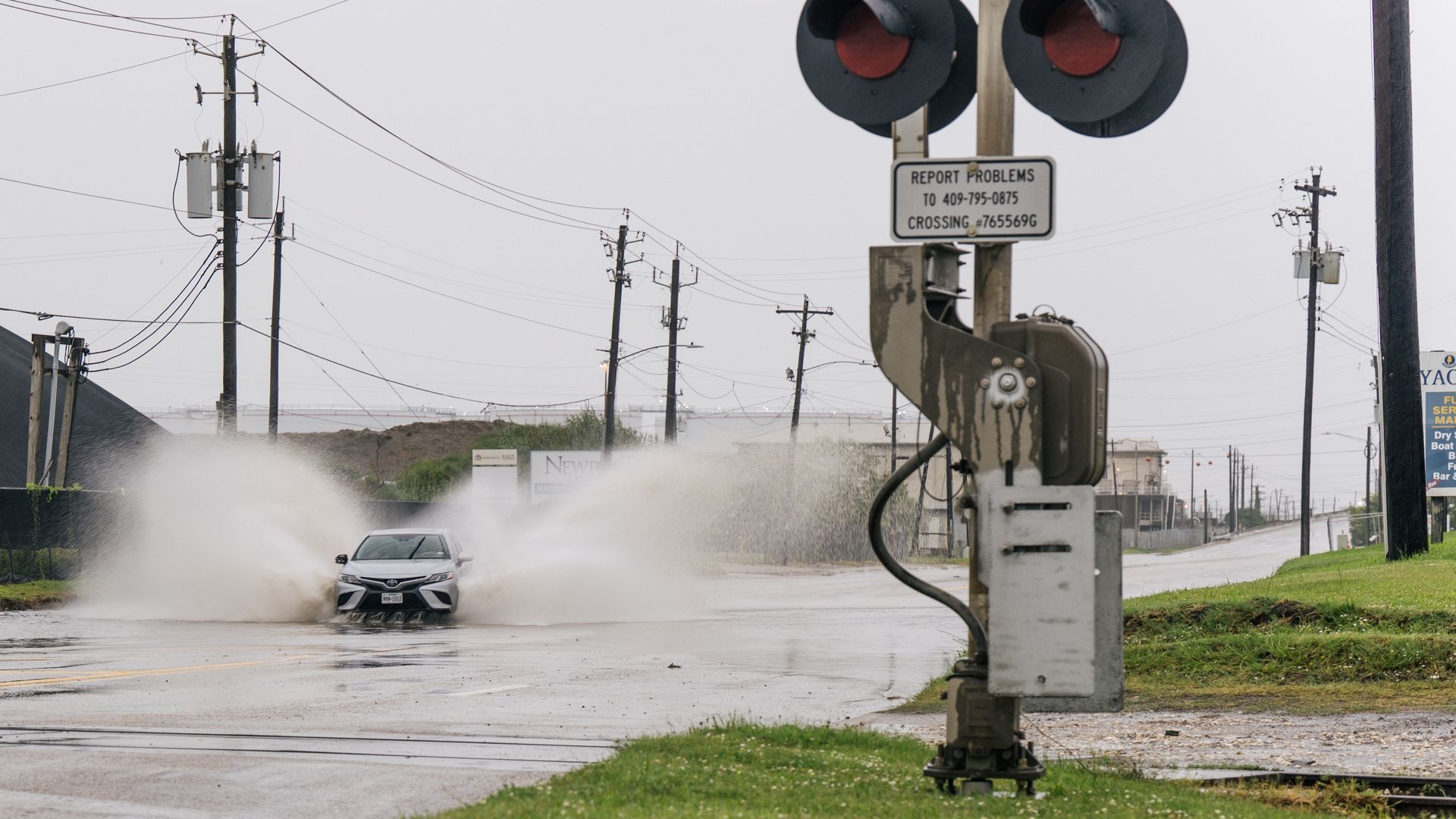 A car splashes water on a partially flooded roadway in Galveston