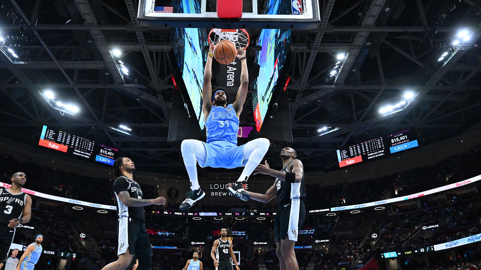 Cavs center Jarrett Allen dunks while wearing powder blue jerseys against San Antonio Spurs (black jerseys)