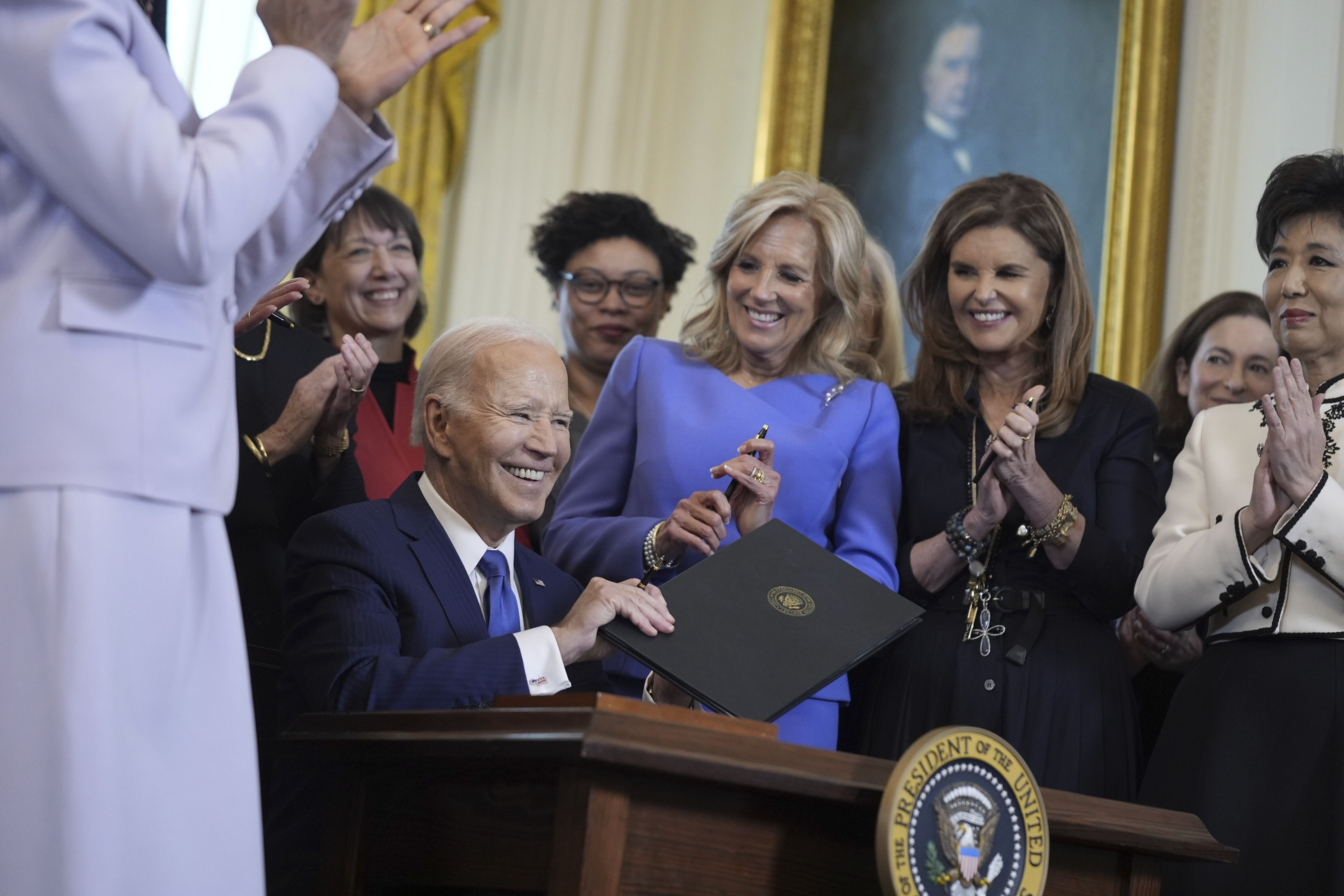 President Biden smiles after signing an executive order on women's health yesterday.