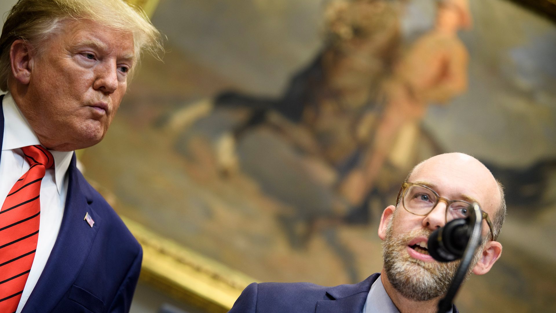 President Donald Trump listens while acting OMB Director Russell Vought speaks