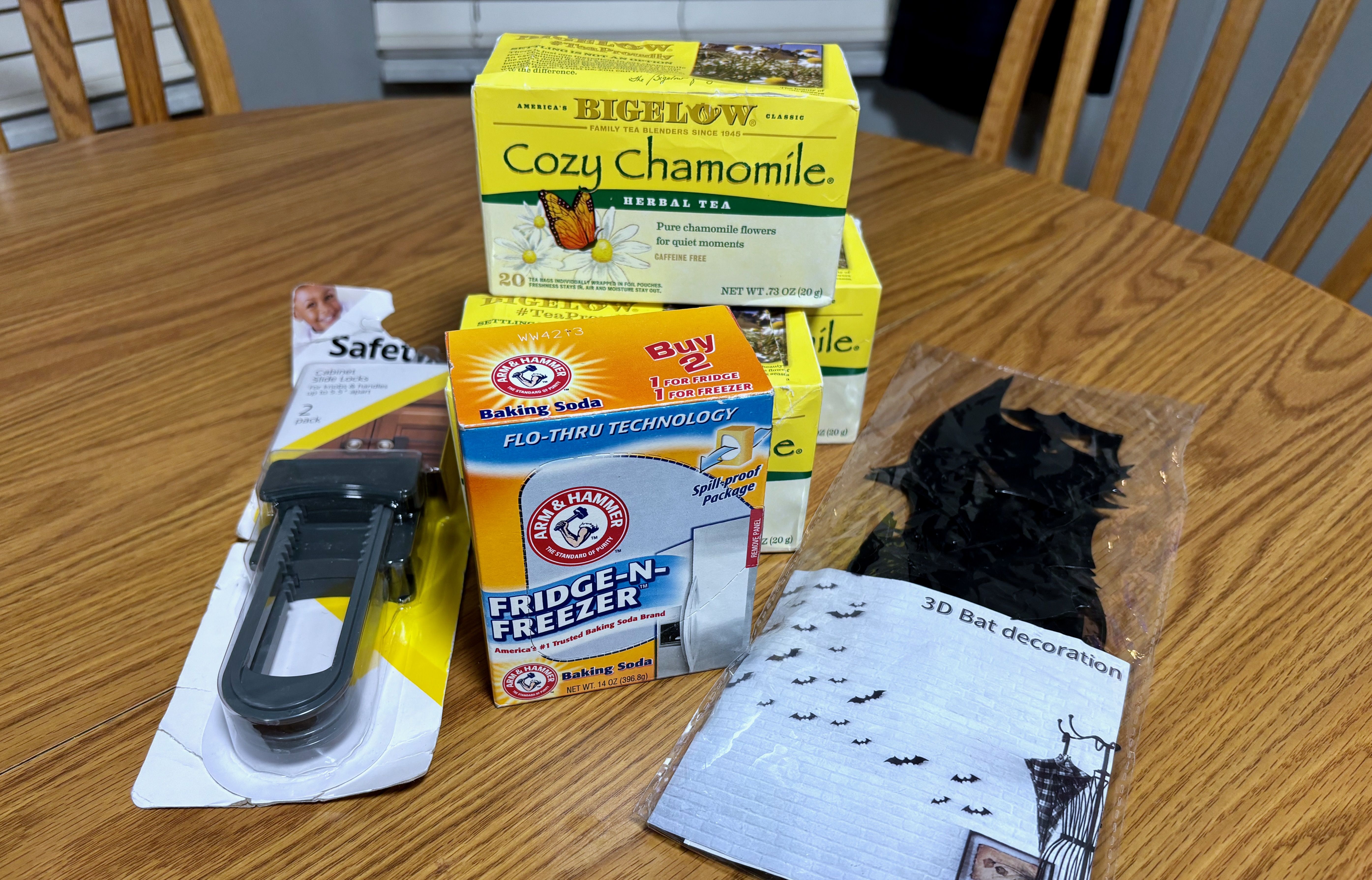 A pile of items from Where Ya Bin,  including a box of baking soda, "cozy chamomile tea" and plastic bat Halloween decorations