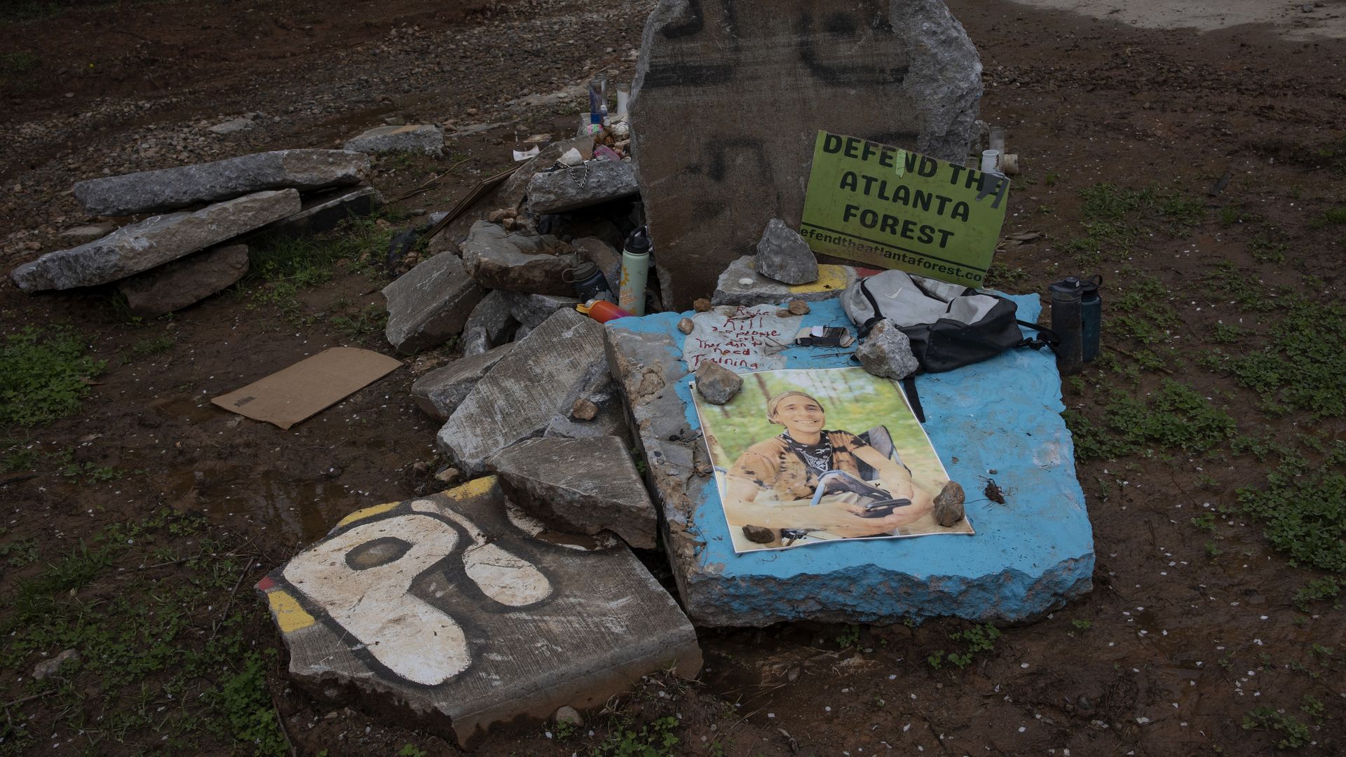 A photo of an activist who was shot and killed by law enforcement after, the officers say, opening fire "without warning," is placed on concrete blocks with a sign that says "Defend the Atlanta Forest" 