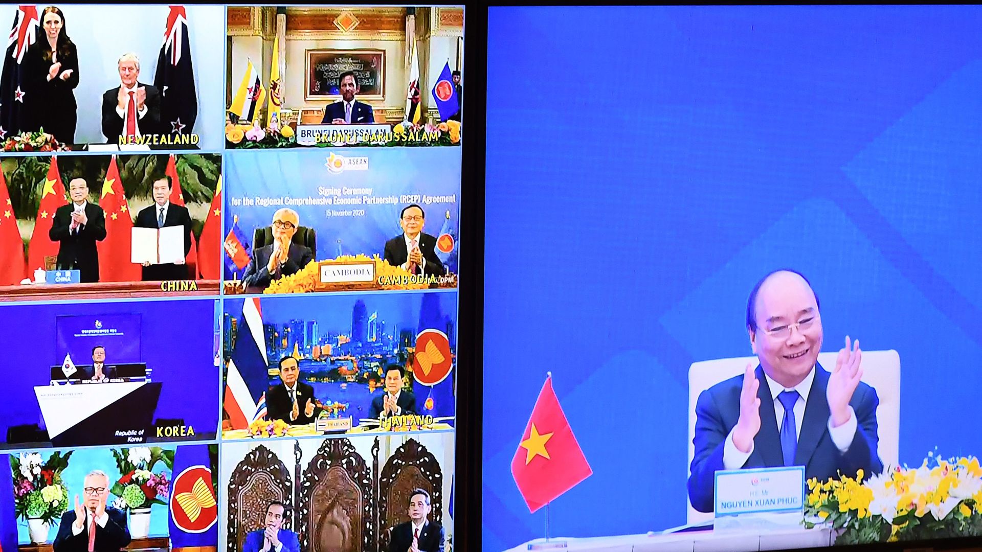 Vietnam's Prime Minister Nguyen Xuan Phuc (R) clapping next to other country signatories during the signing ceremony for the Regional Comprehensive Economic Partnership (RCEP) trade pact
