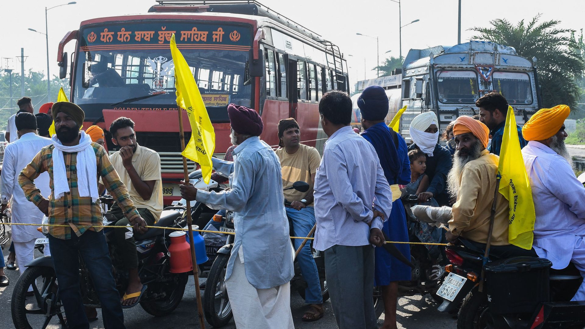 Picture of Indian farmers standing in front of two buses