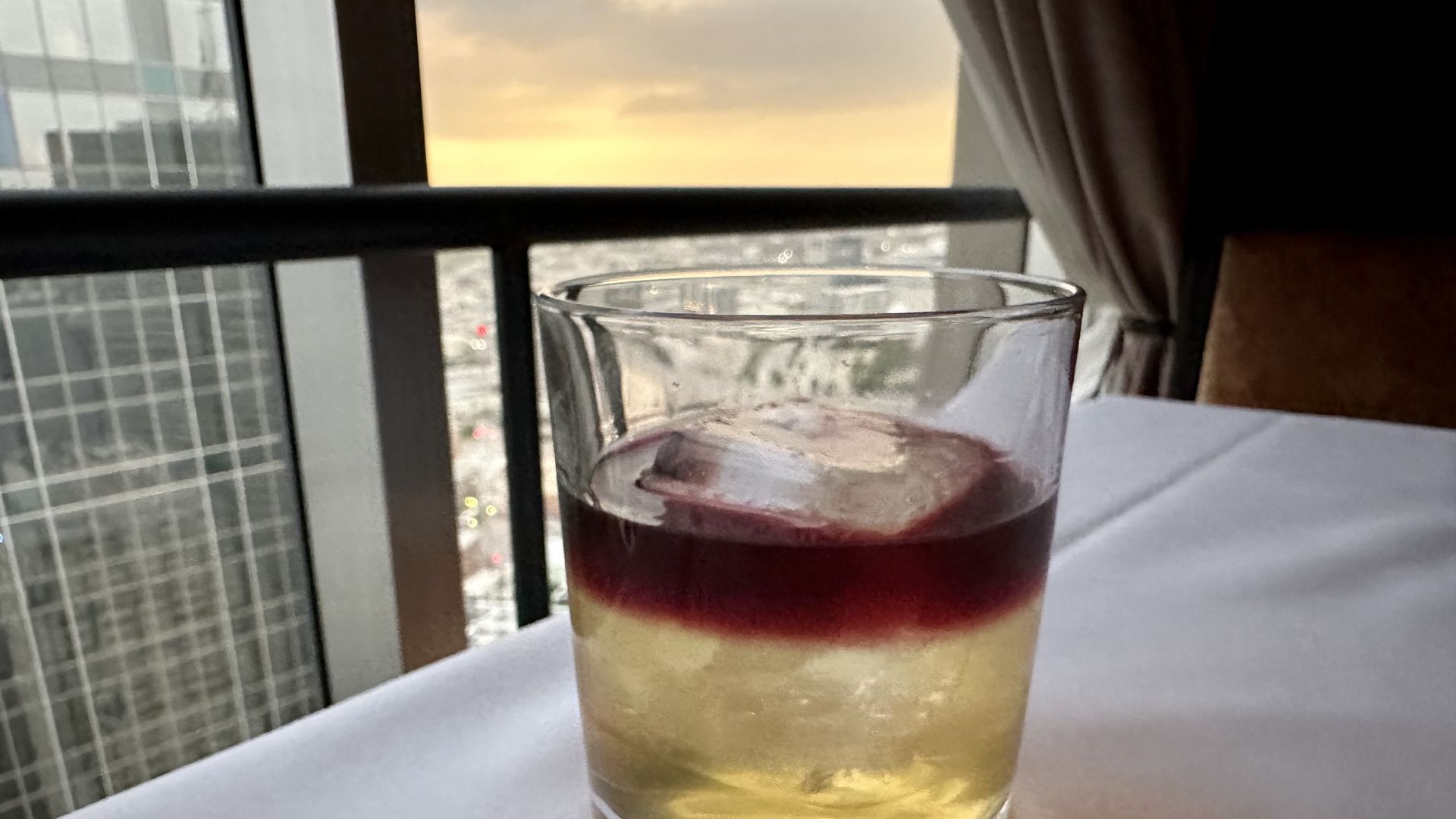 A photo of a cocktail in front of a window 