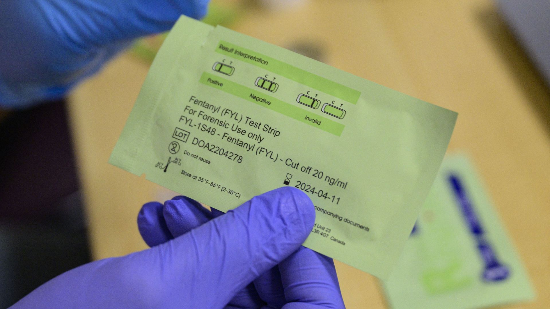 Fentanyl test strip package being held by gloved hands