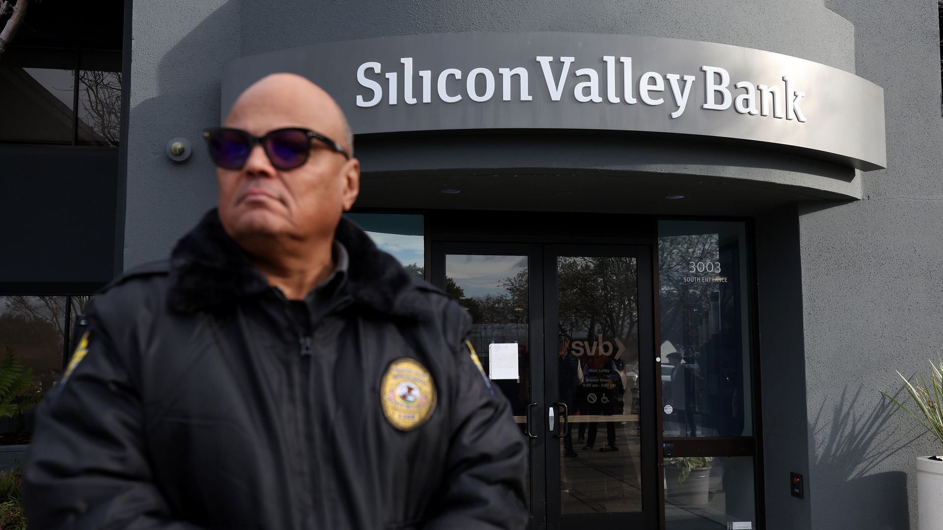 A security guard with sunglasses is standing guard outside Silicon Valley Bank in Santa Clara, California.