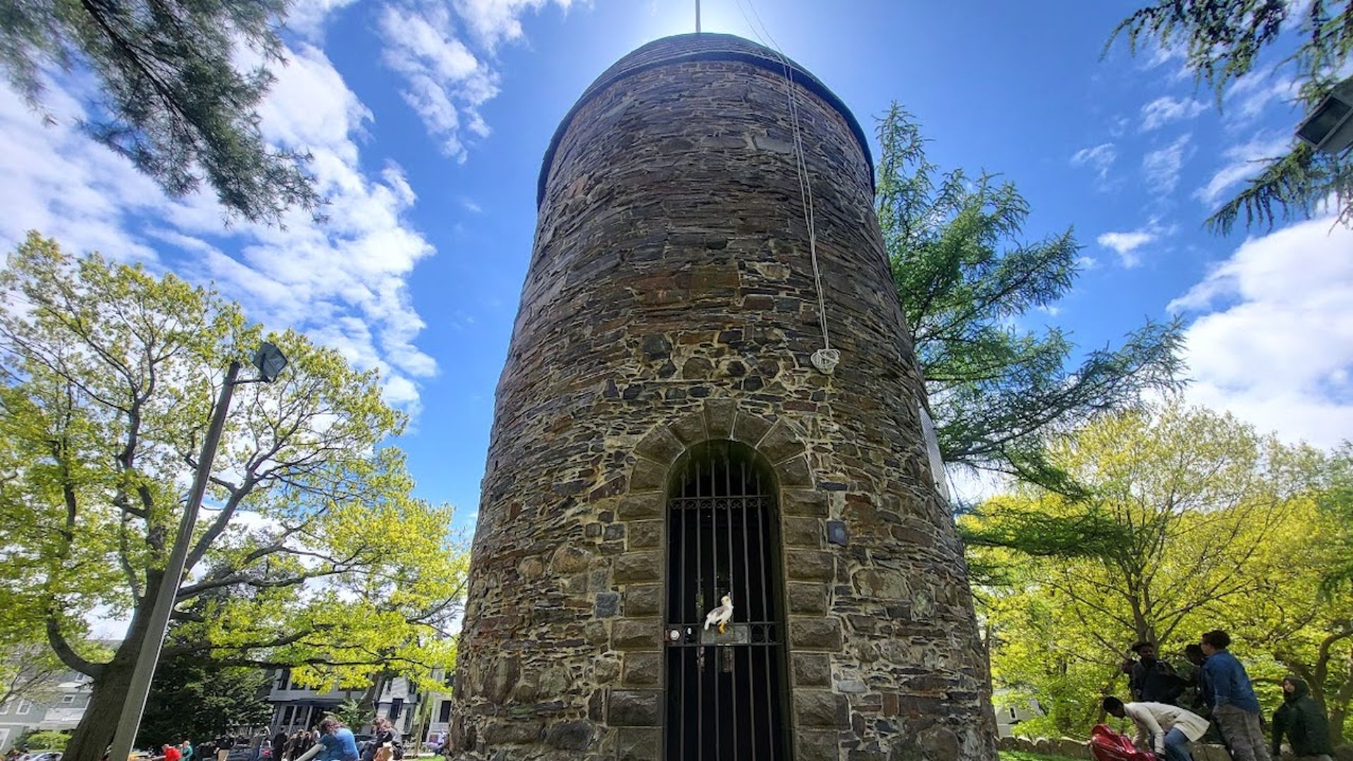 Townie, Axios Boston's plush gullscot, sits perched on a metal gate of the Old Powder House, located in Somerville's Nathan Tufts Park. 