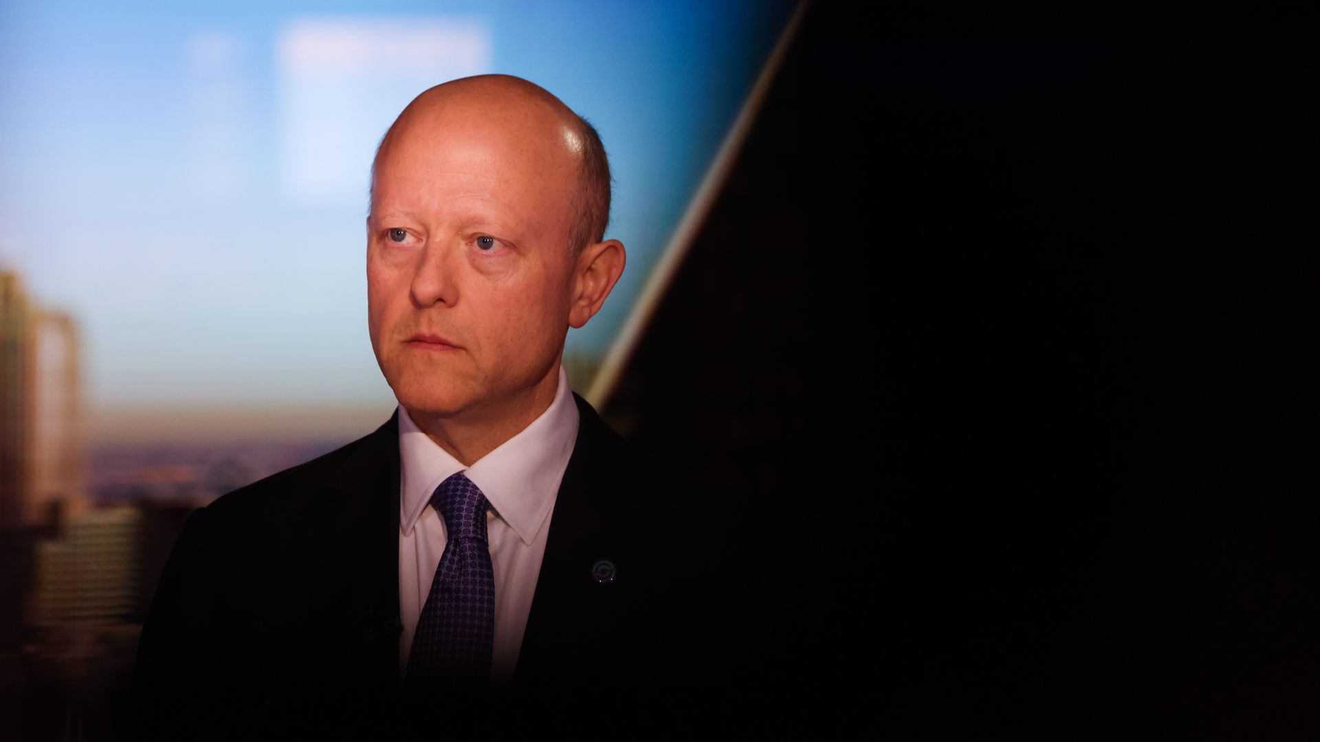 Middle-aged white man with receding hair in a business suit.