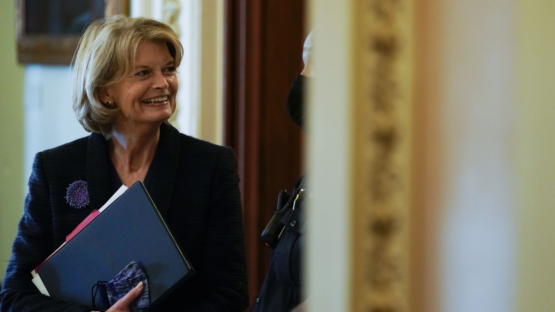 Senator Lisa Murkowski (R-AK) speaks with a security guard as she stands outside the Senate Chamber on Capitol Hill on November 3, 2021 in Washington, DC.