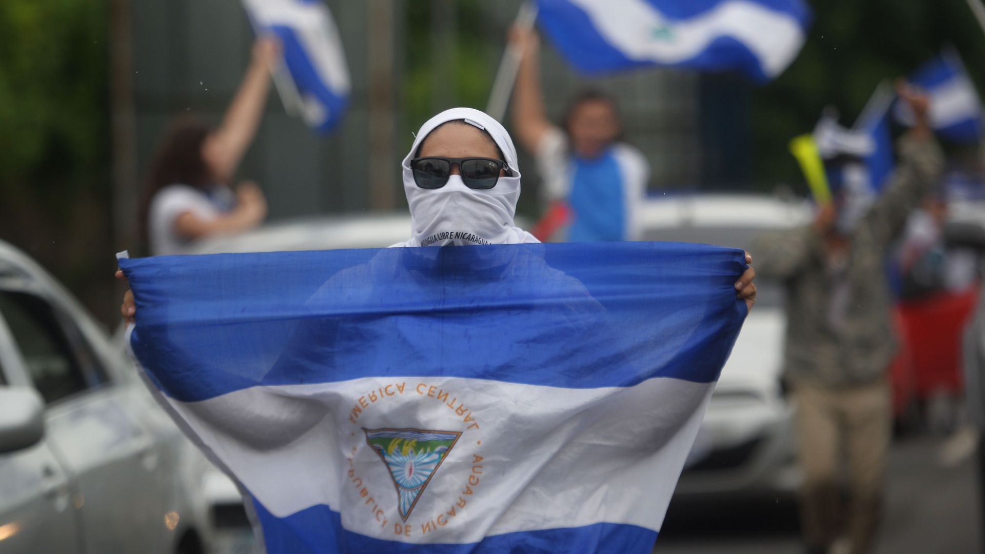 A demonstrator holds a Nicaraguan flag during the march in cars and motorcycles from Managua to Ticuantepe, 15km south of Managua.