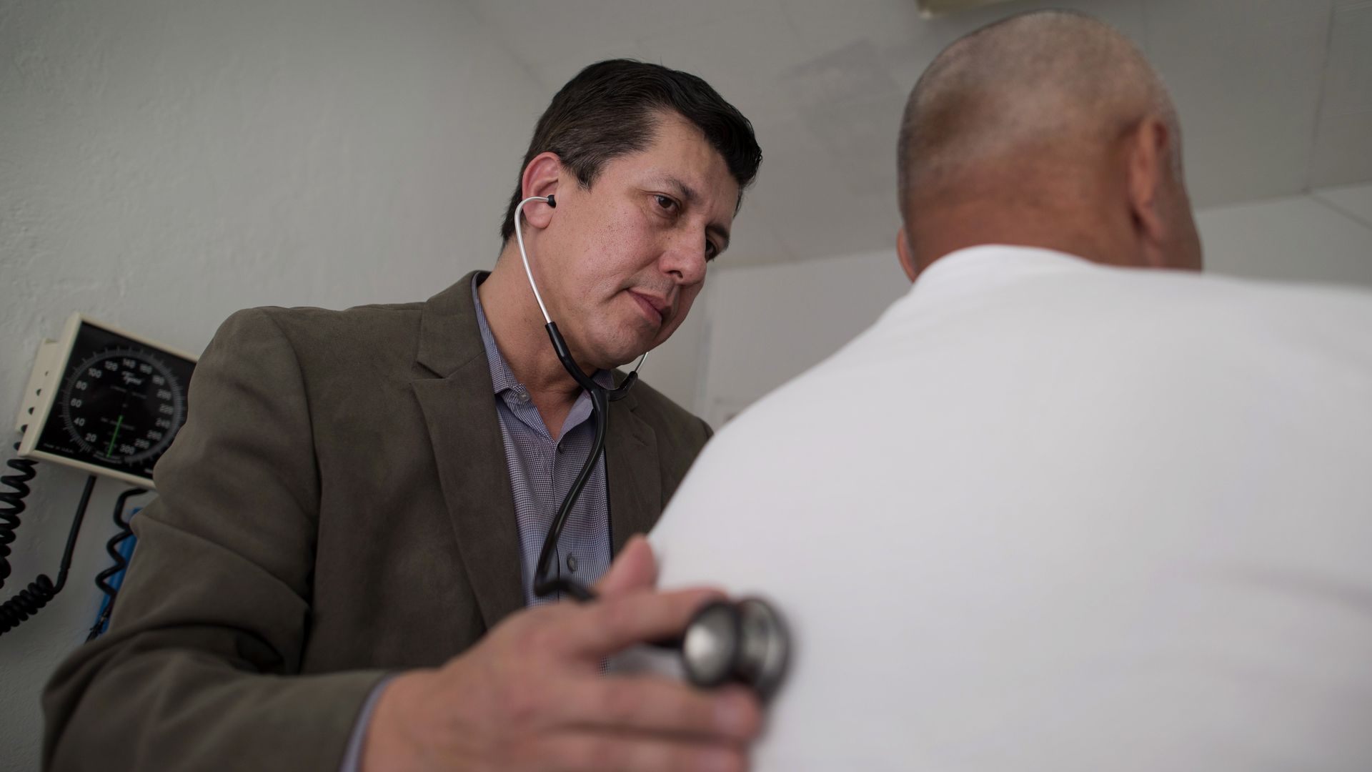 Dr. Esteban Lovato uses a stethoscope to examine a patient. 