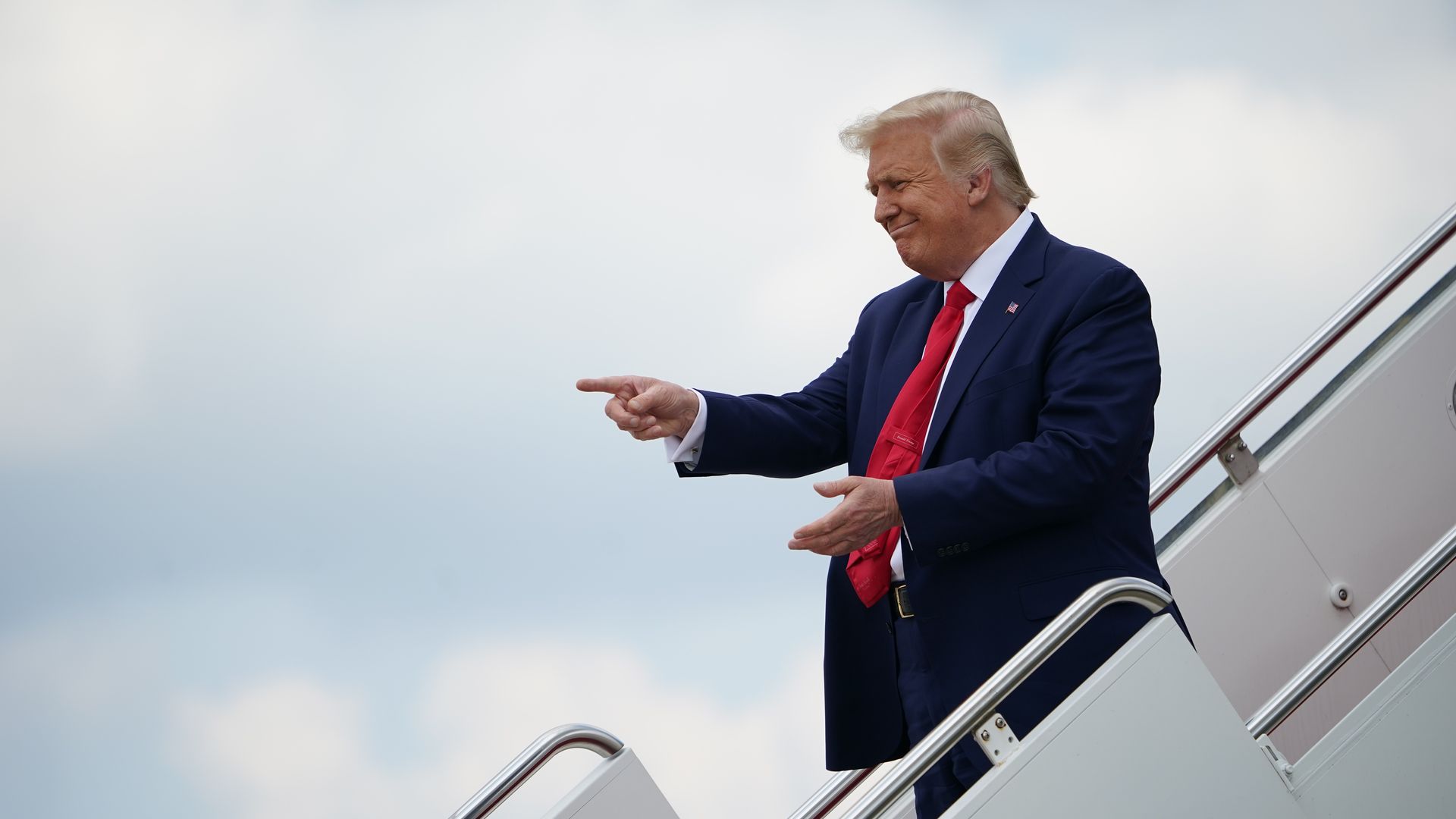 A photo of President Donald Trump walking down the stairs from Air Force One.