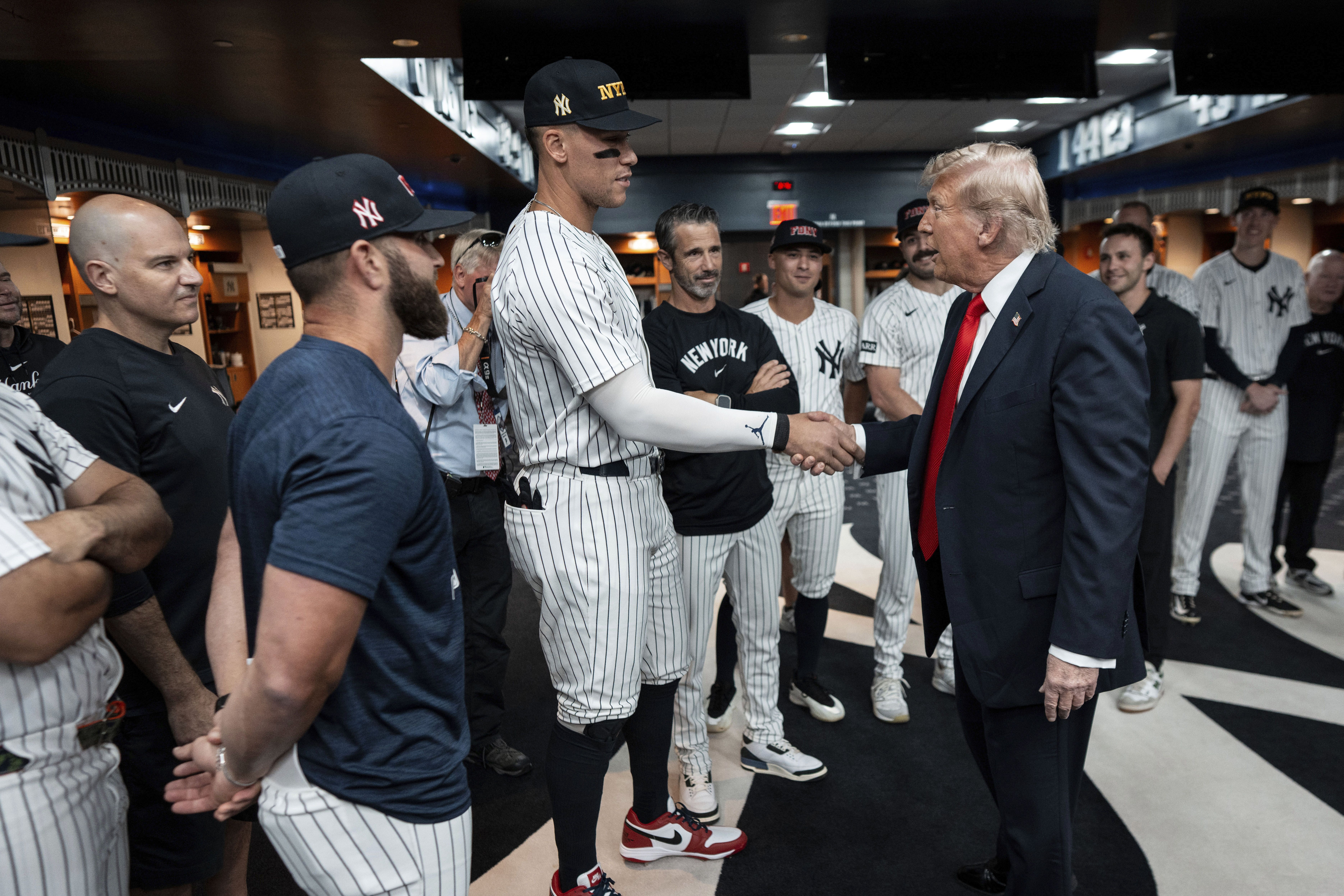 President Trump shakes hands with New York Yankees star Aaron Judge in the team's clubhouse at Yankee Stadium before a game last night.