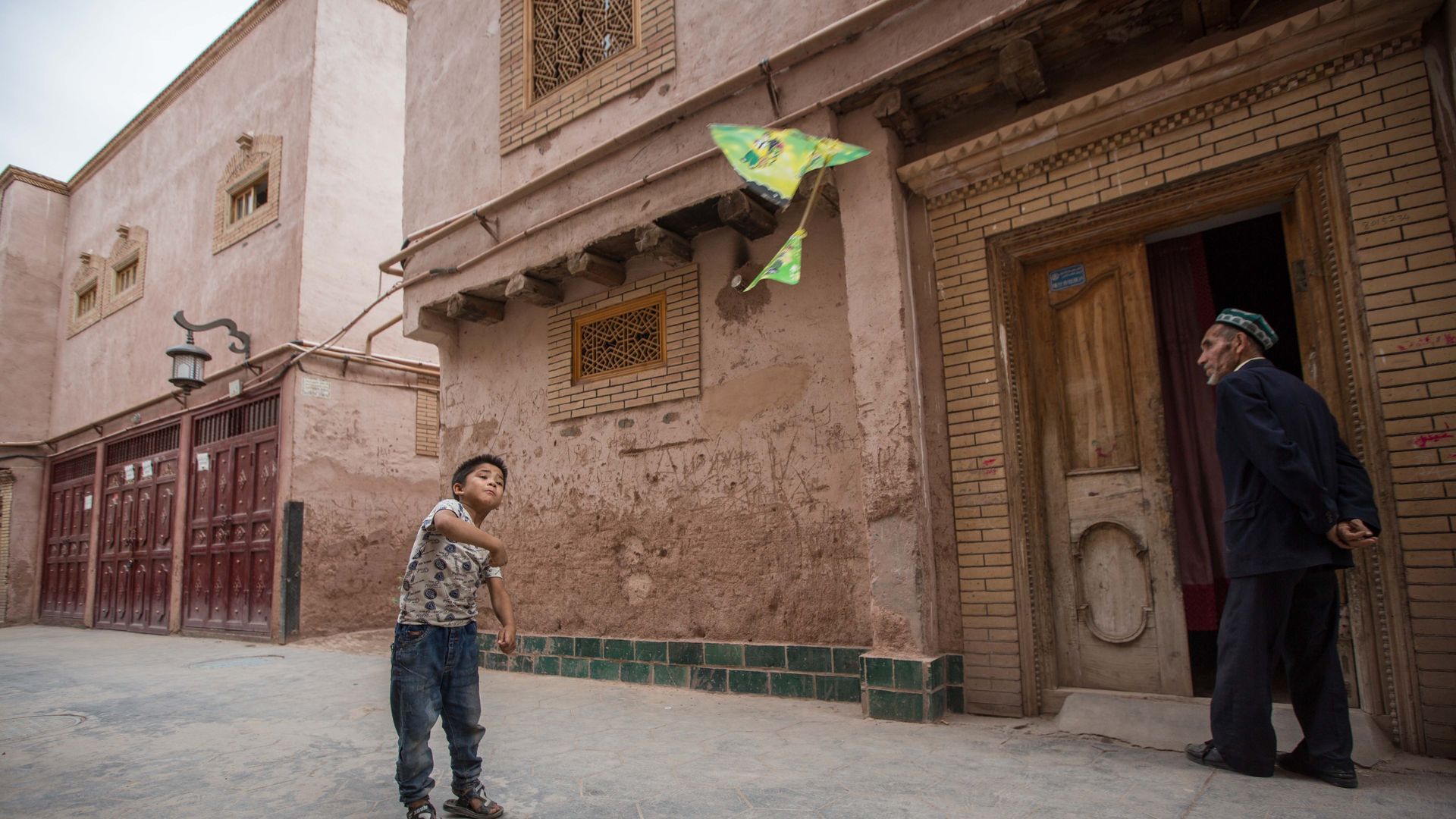 Photo of Uighur kid throwing a paper airplane during happier times in Xinjiang