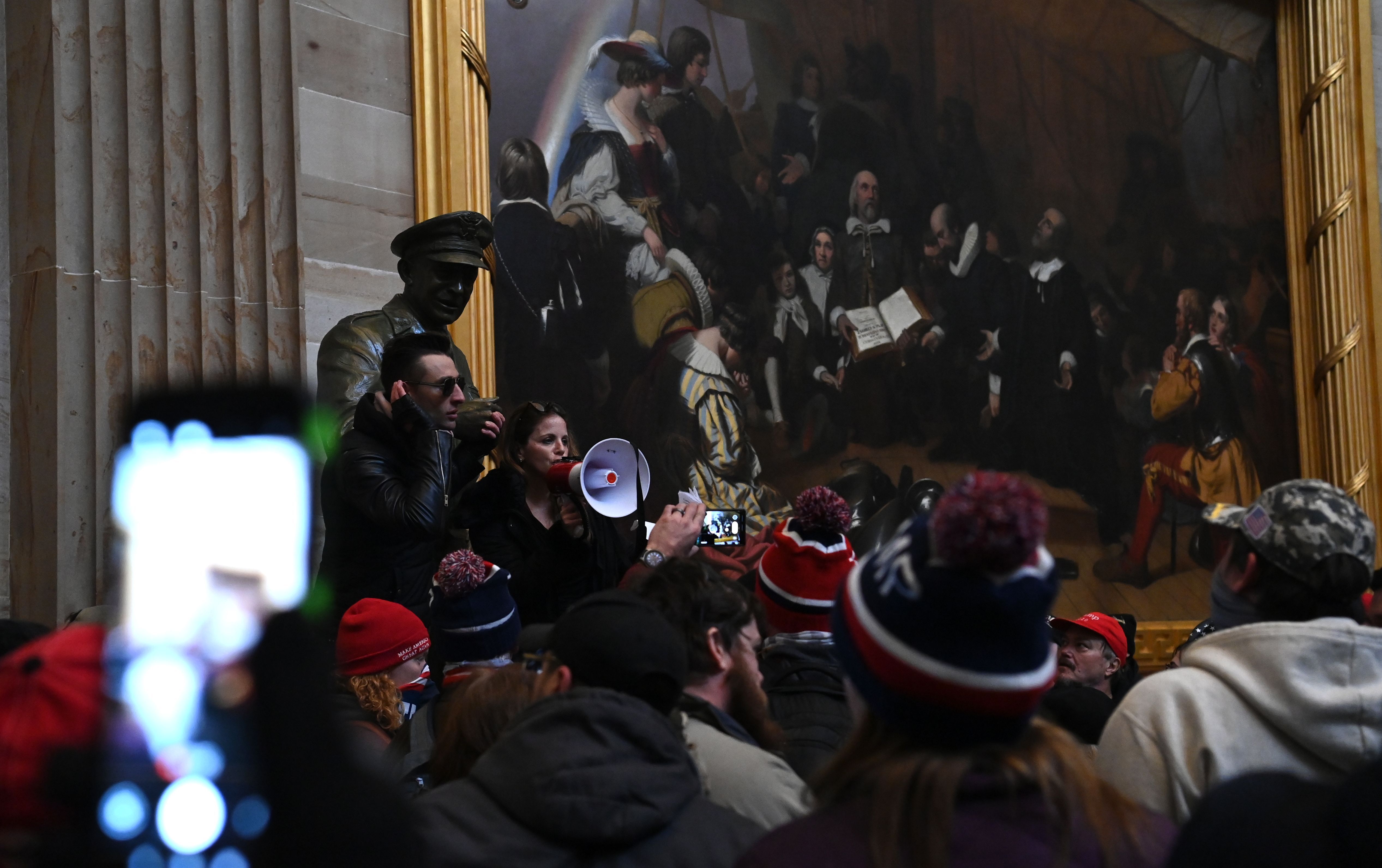 protetsors in front of a painting