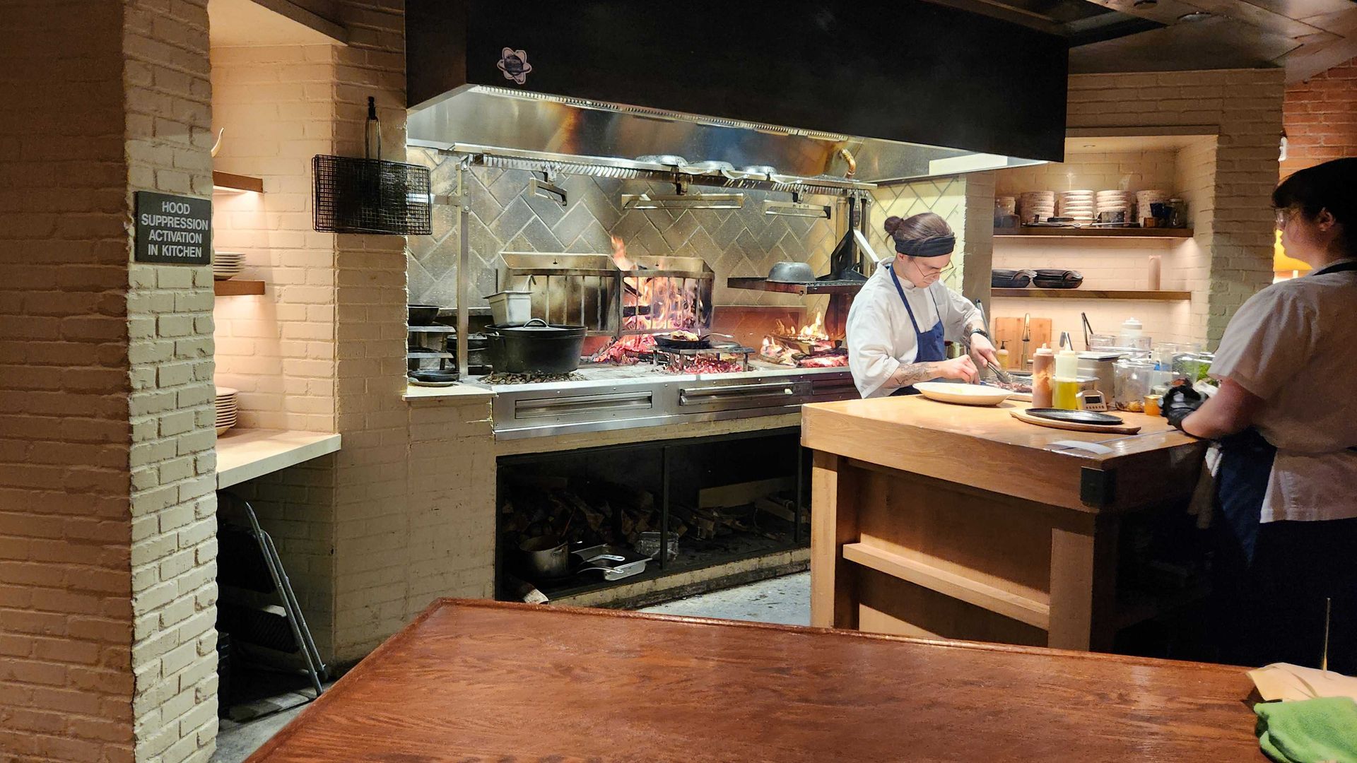 A wood-fire hearth and chefs at Little West Tavern.