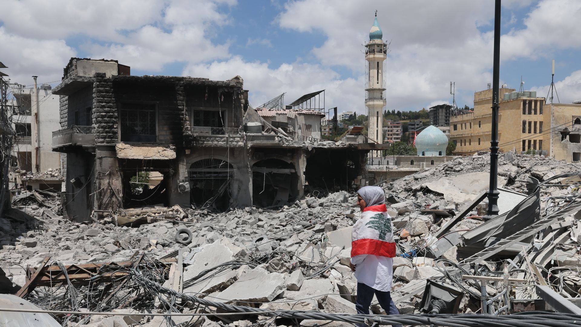 Woman in flag in rubble