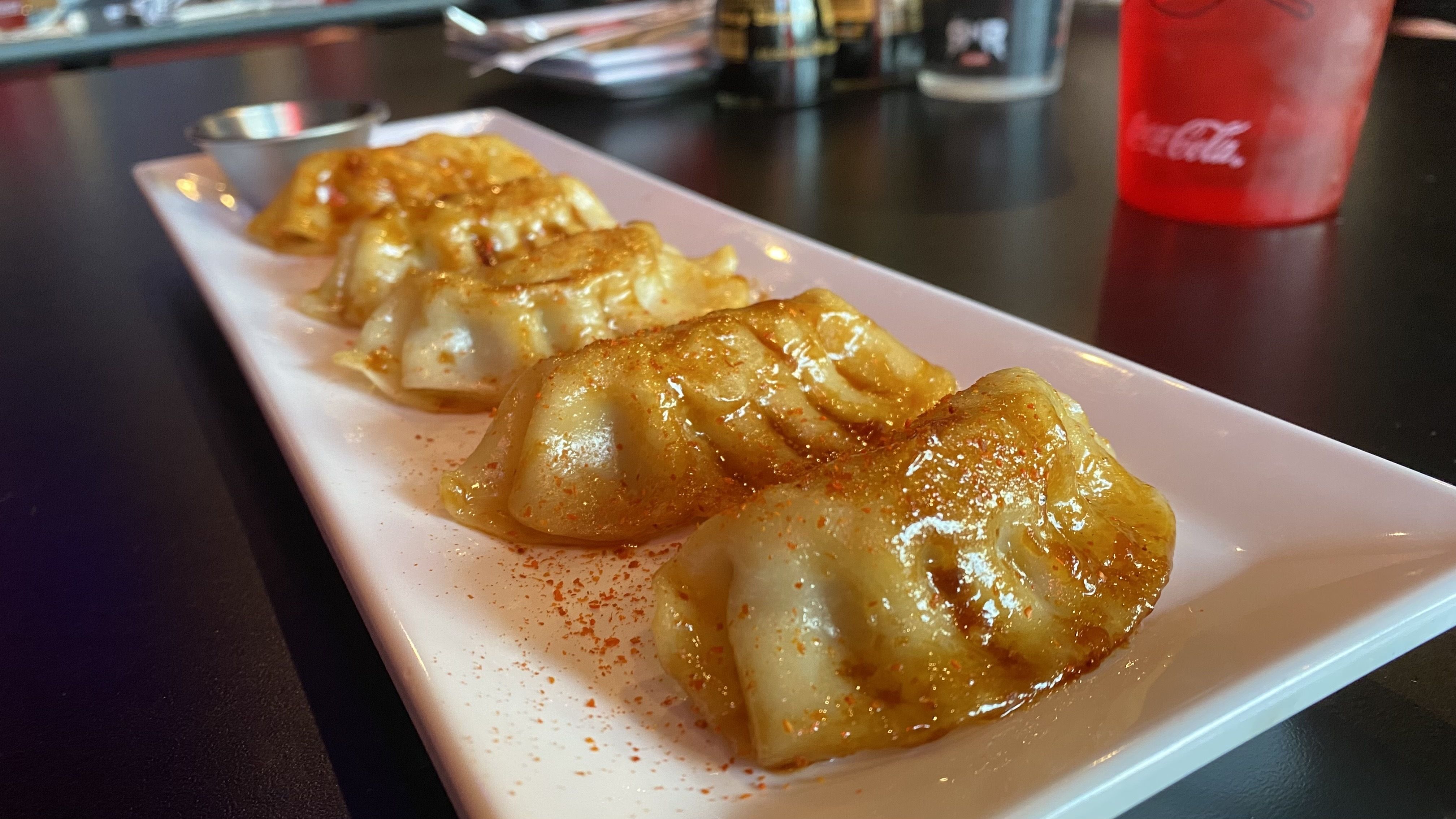 A photo of a plate of pot stickers. 
