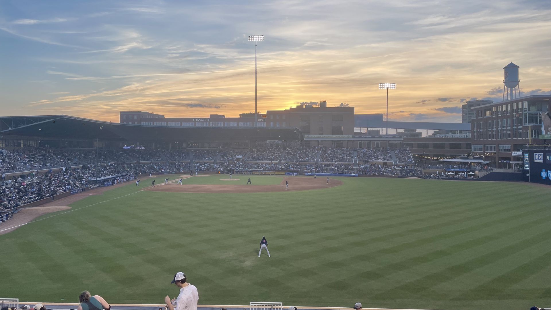 The view from the outfield of the Durham Bulls Athletic Park, with a sunset in the distance. 