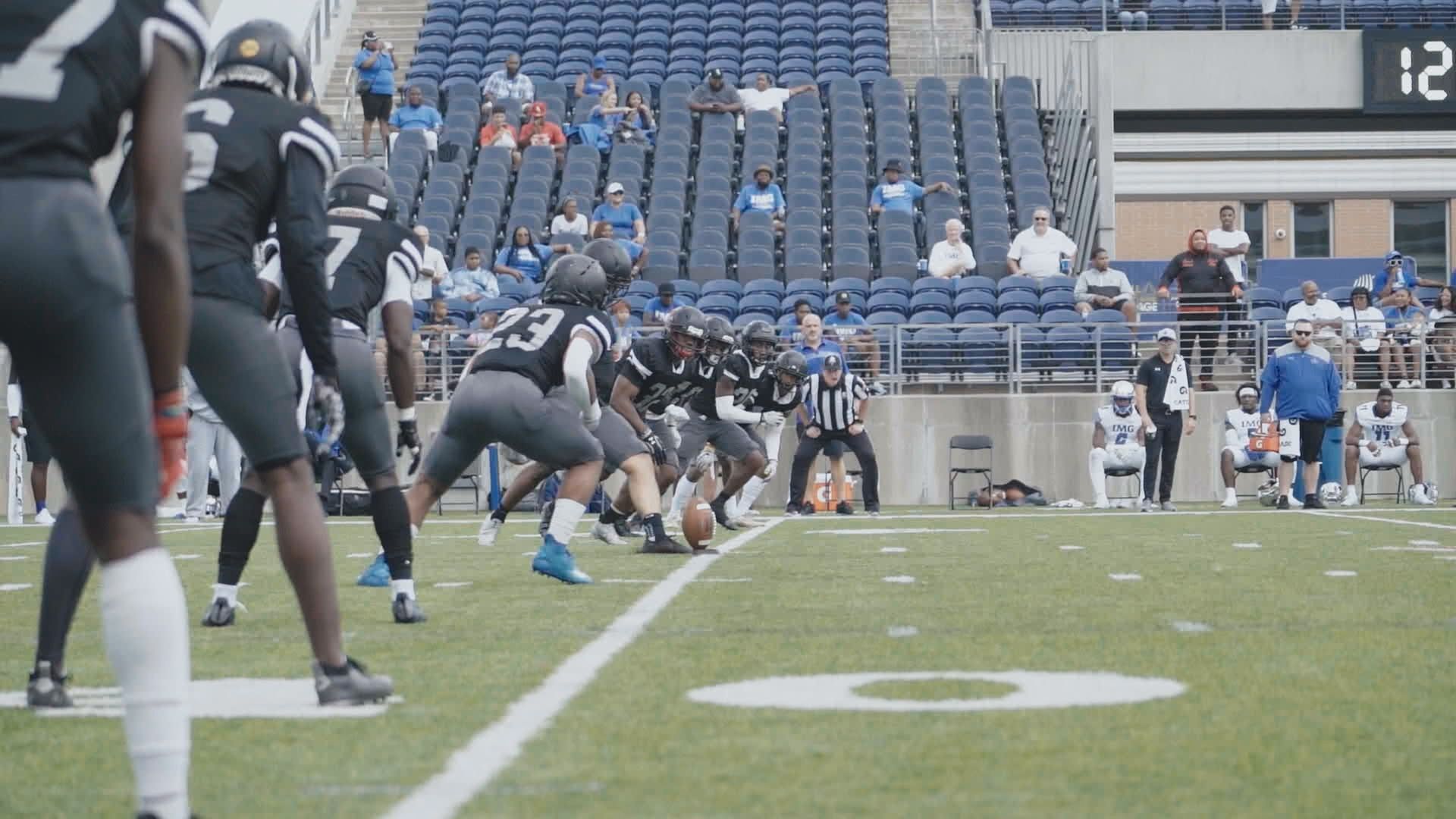 A line of football players prepares for kickoff on a football field
