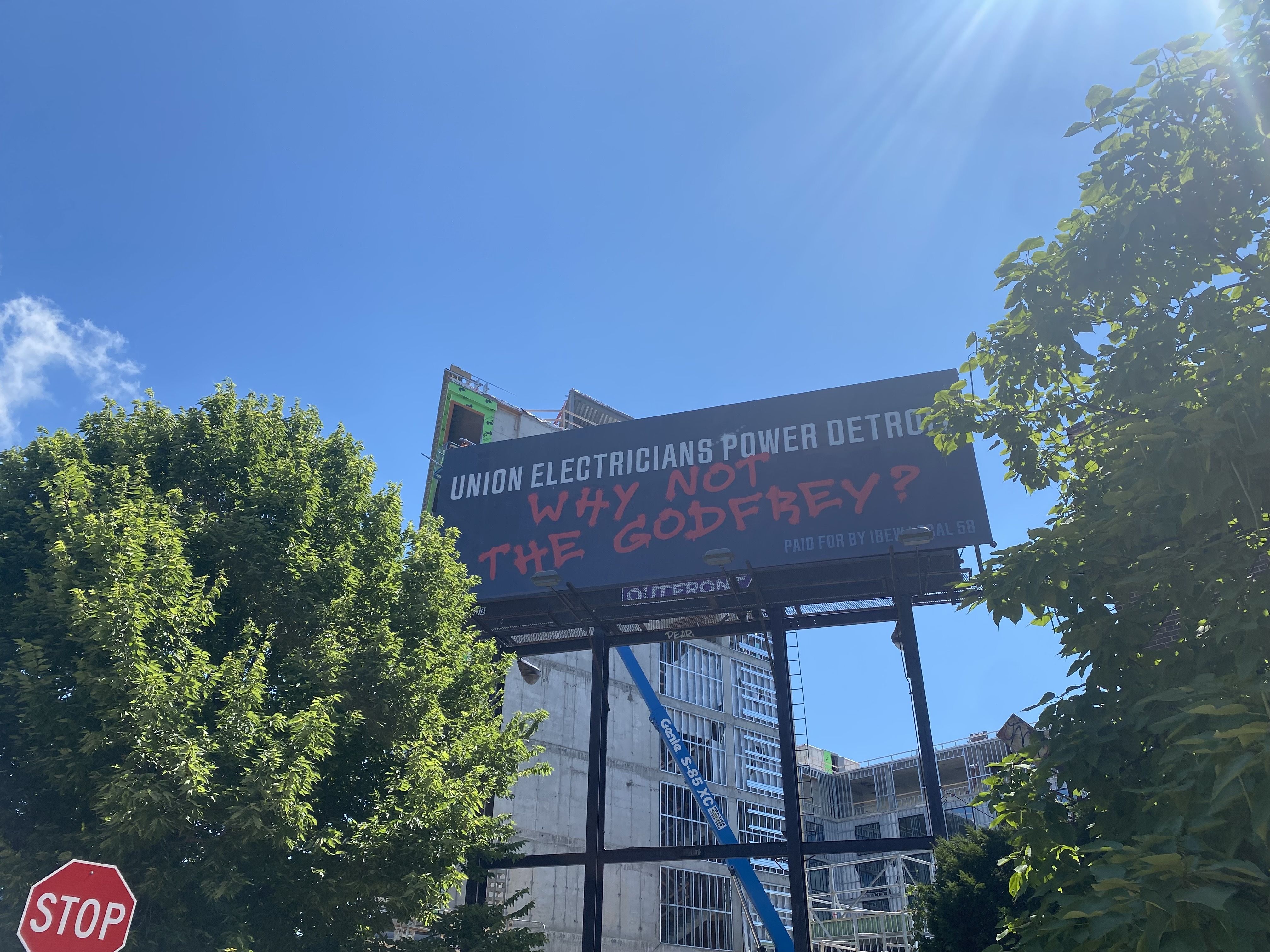 A billboard says "Union electricians power Detroit" then "Why not the Godfrey?"