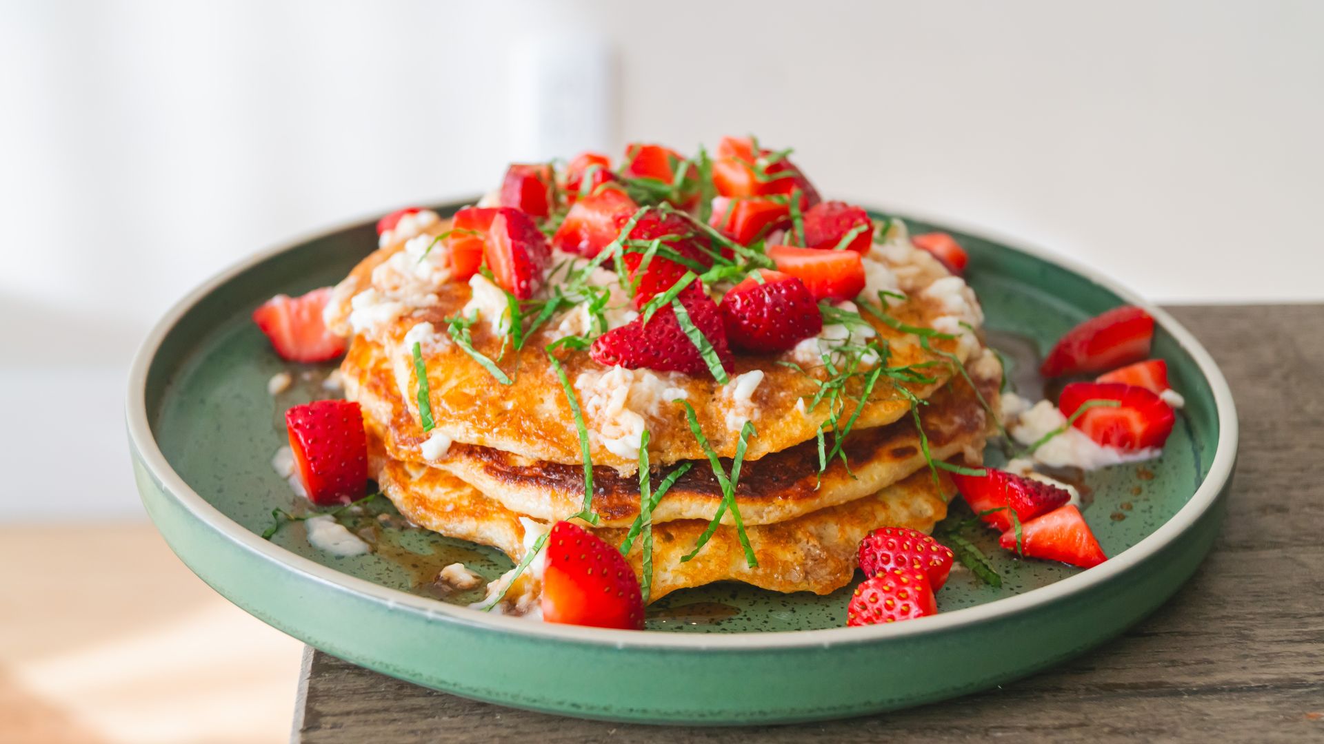 Corn meal pancakes topped with strawberries.